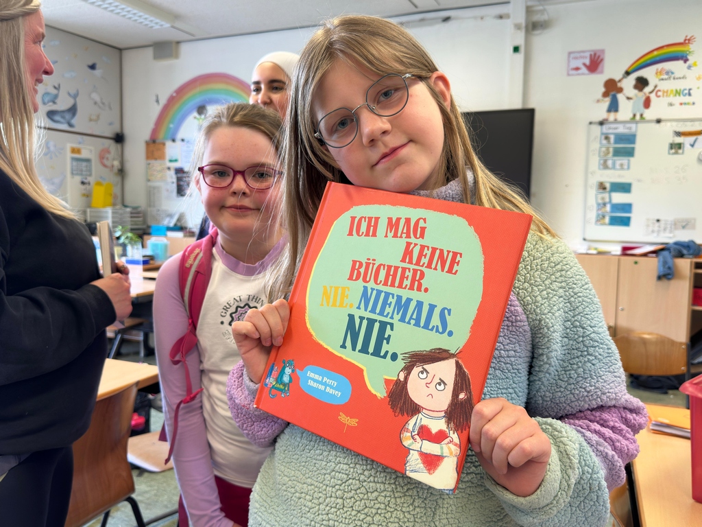 Mädchen hält stolz das Buch "Ich mag keine Bücher. Nie. Niemals. Nie." in die Kamera