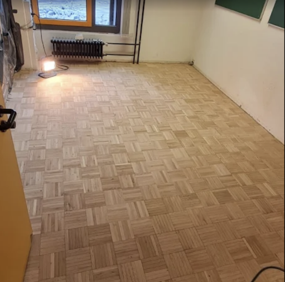 Mosaikparkett in einem Raum – Schleifarbeiten laufend