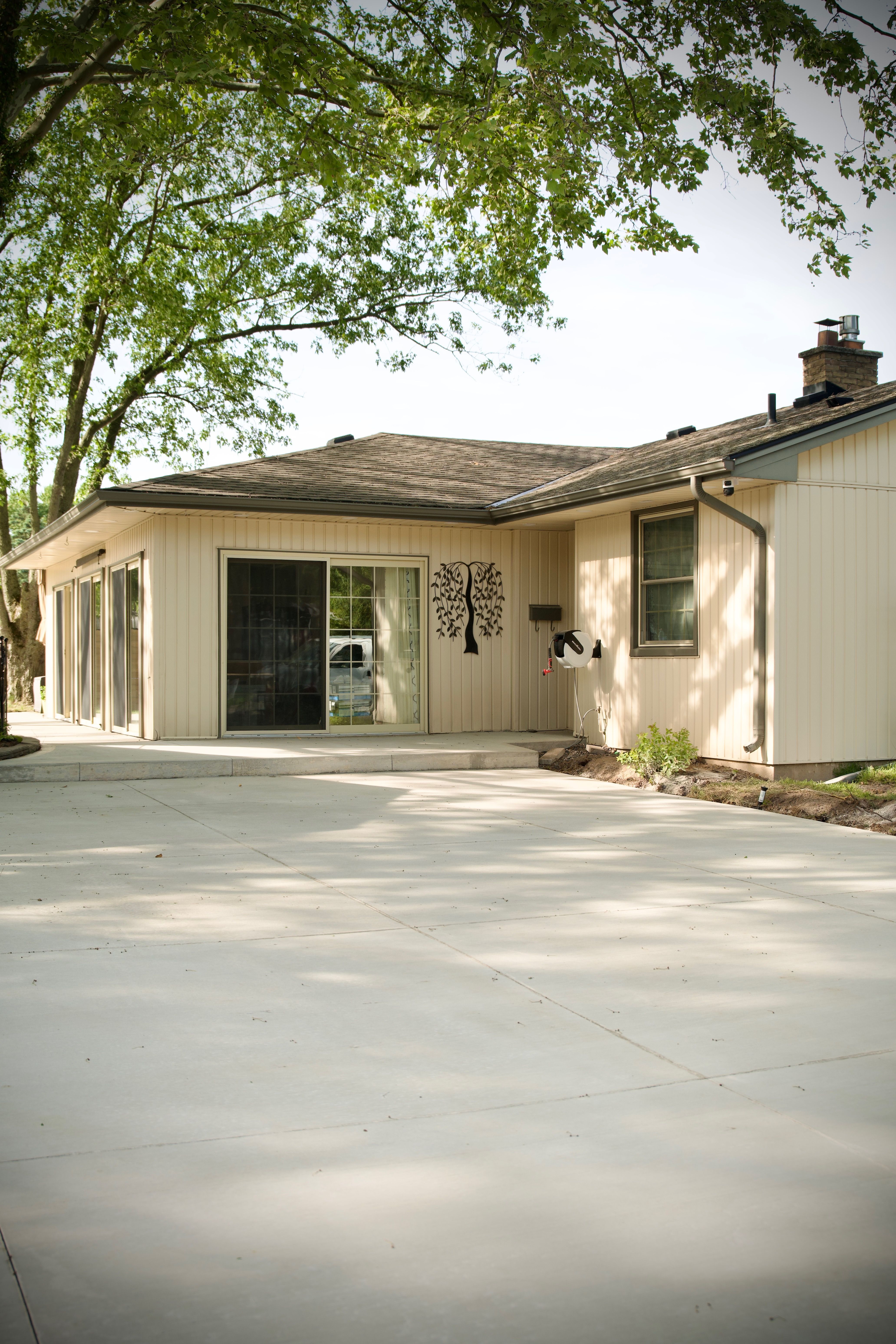 Residential concrete driveway with mature trees — Limestone Concrete Ltd