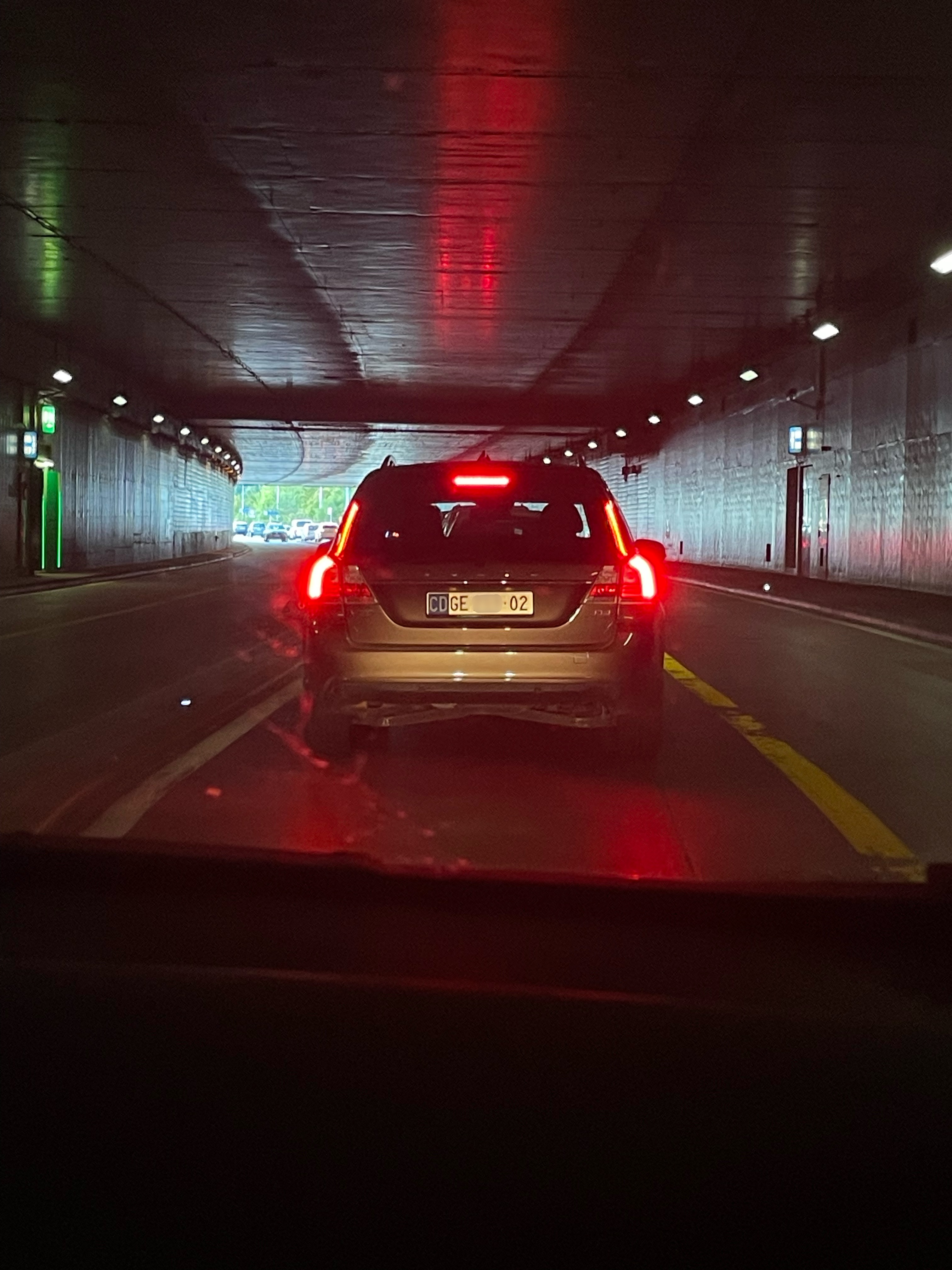 Plaque CD GE • 02 — Canada, corps diplomatique, tunnel de Genève Plaque diplomatique suisse CD GE 02 sur un Volvo V90 gris dans un tunnel à Genève — code 02 correspondant au Canada, canton GE (Genève)