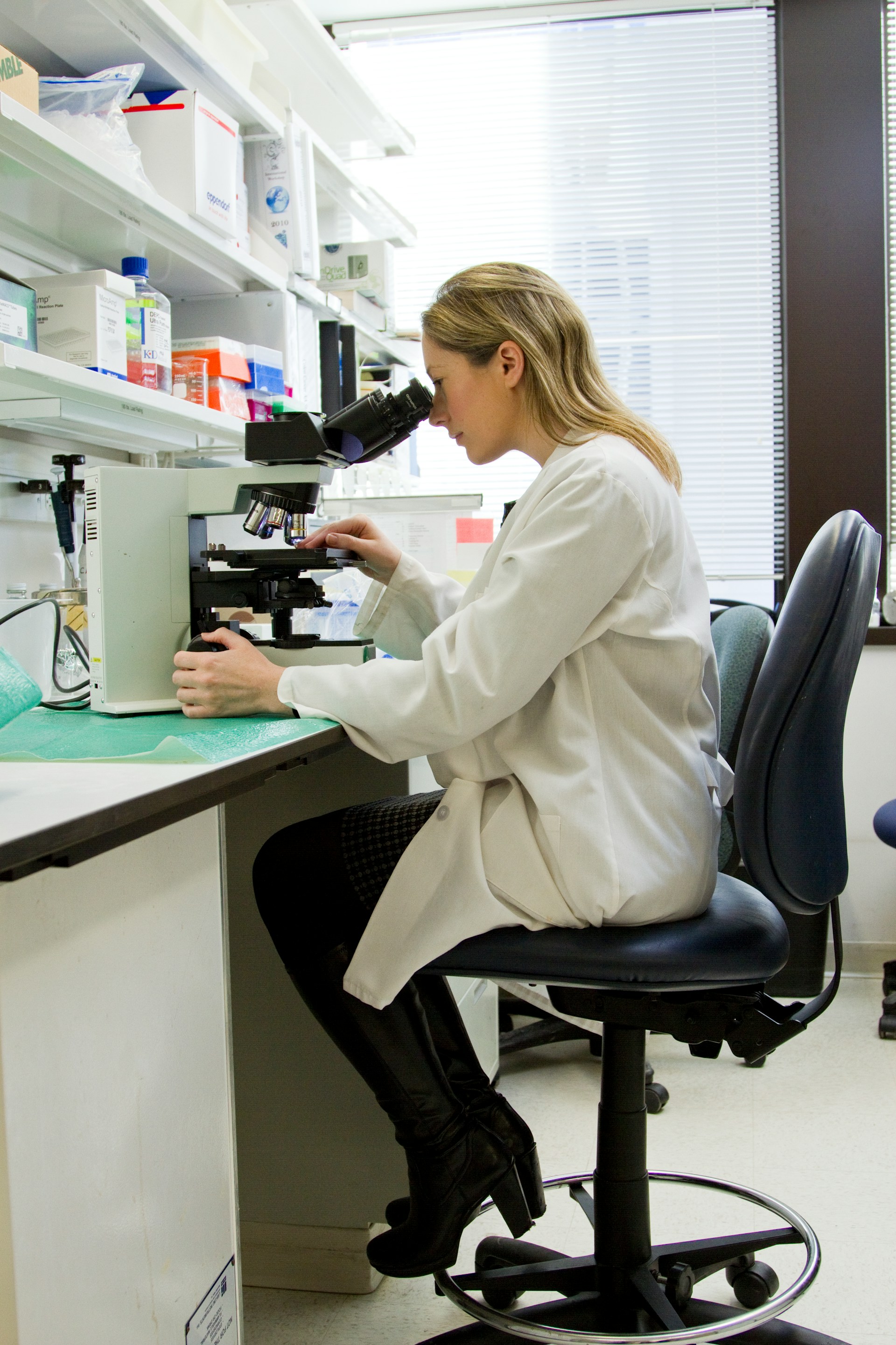 Researcher using microscope in professional lab setting