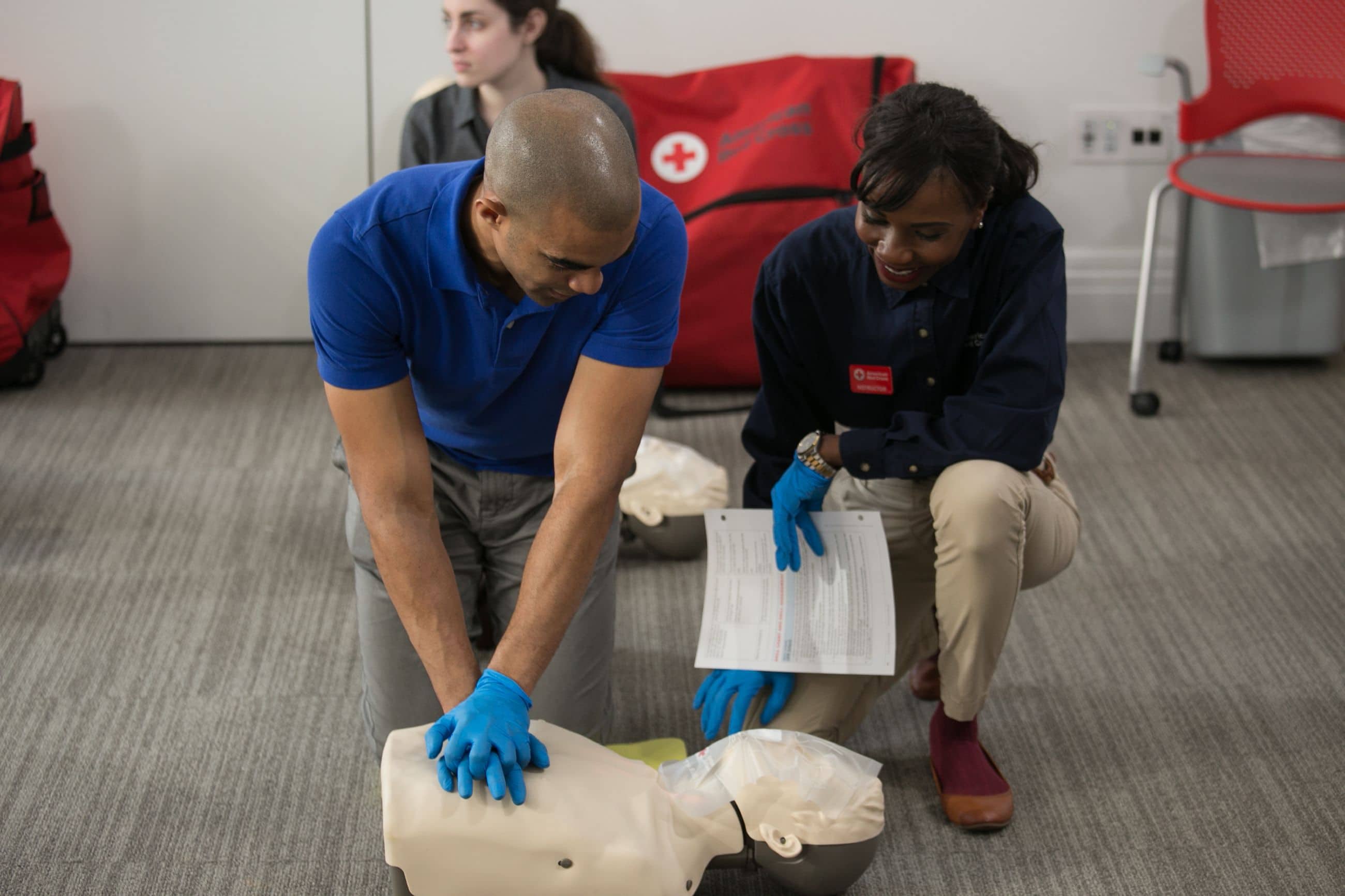 CPR Training Session - Student practicing chest compressions under instructor guidance