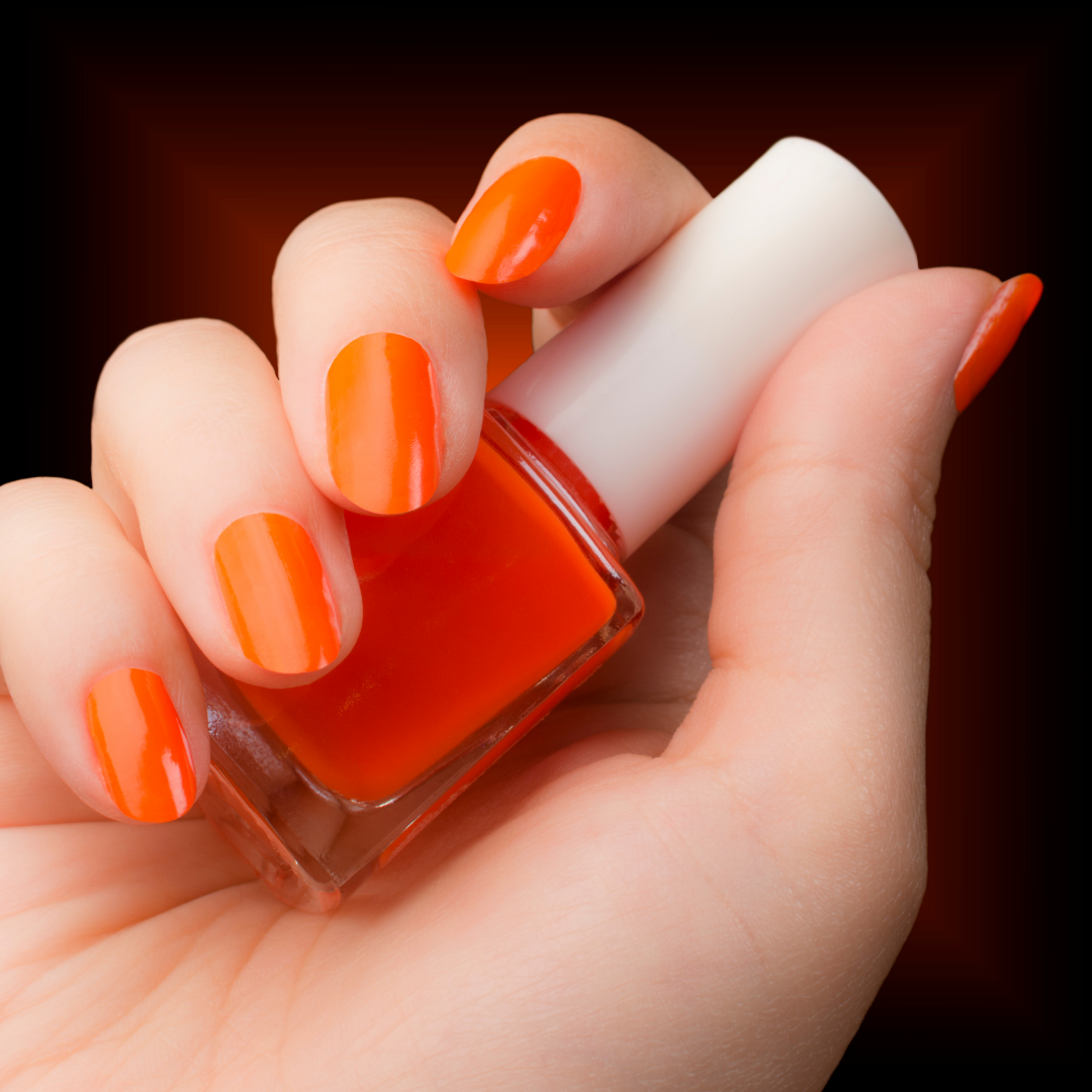 Vibrant orange gel nails with matching nail polish bottle by Colour Workshop Singapore