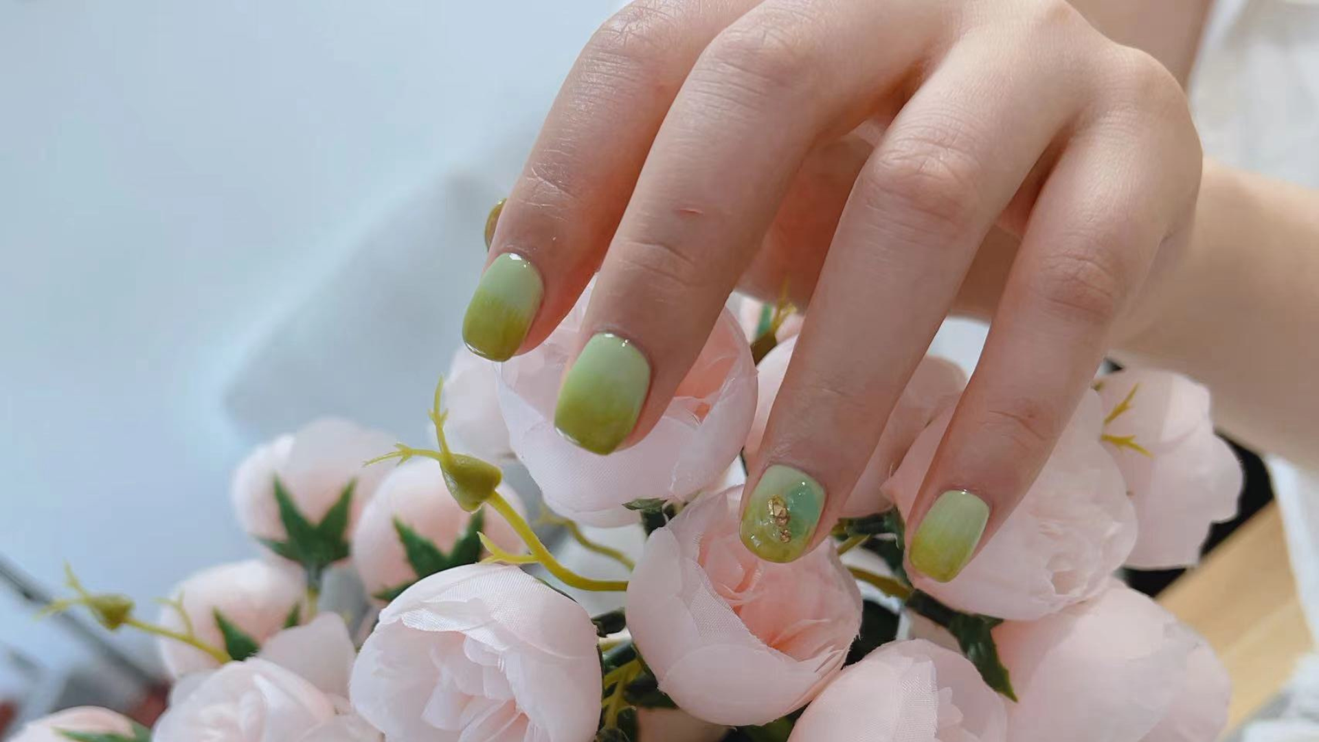 Sage green nails with gold accents over pink roses by Colour Workshop Singapore