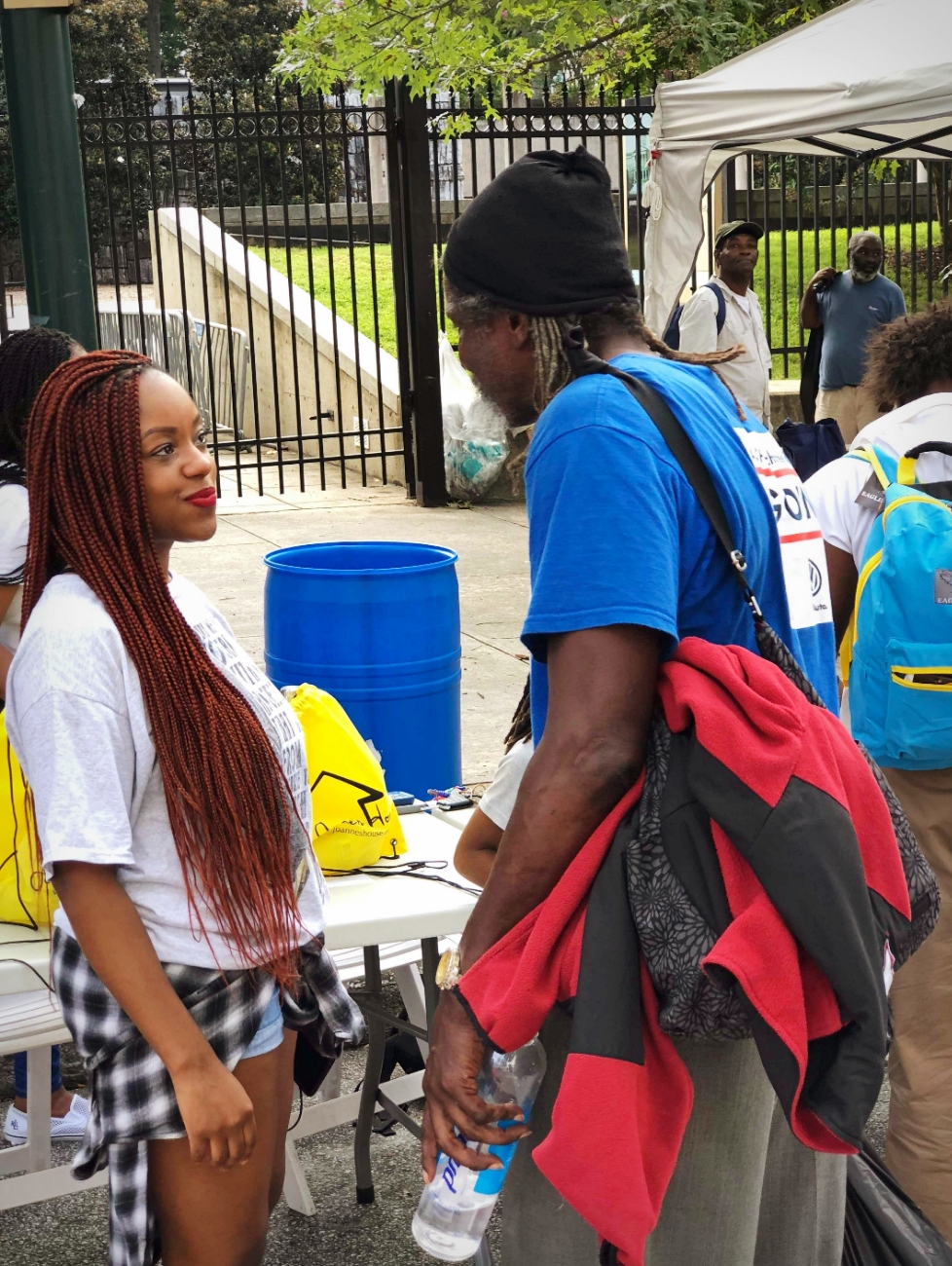 Volunteer speaking with community member at outdoor outreach event
