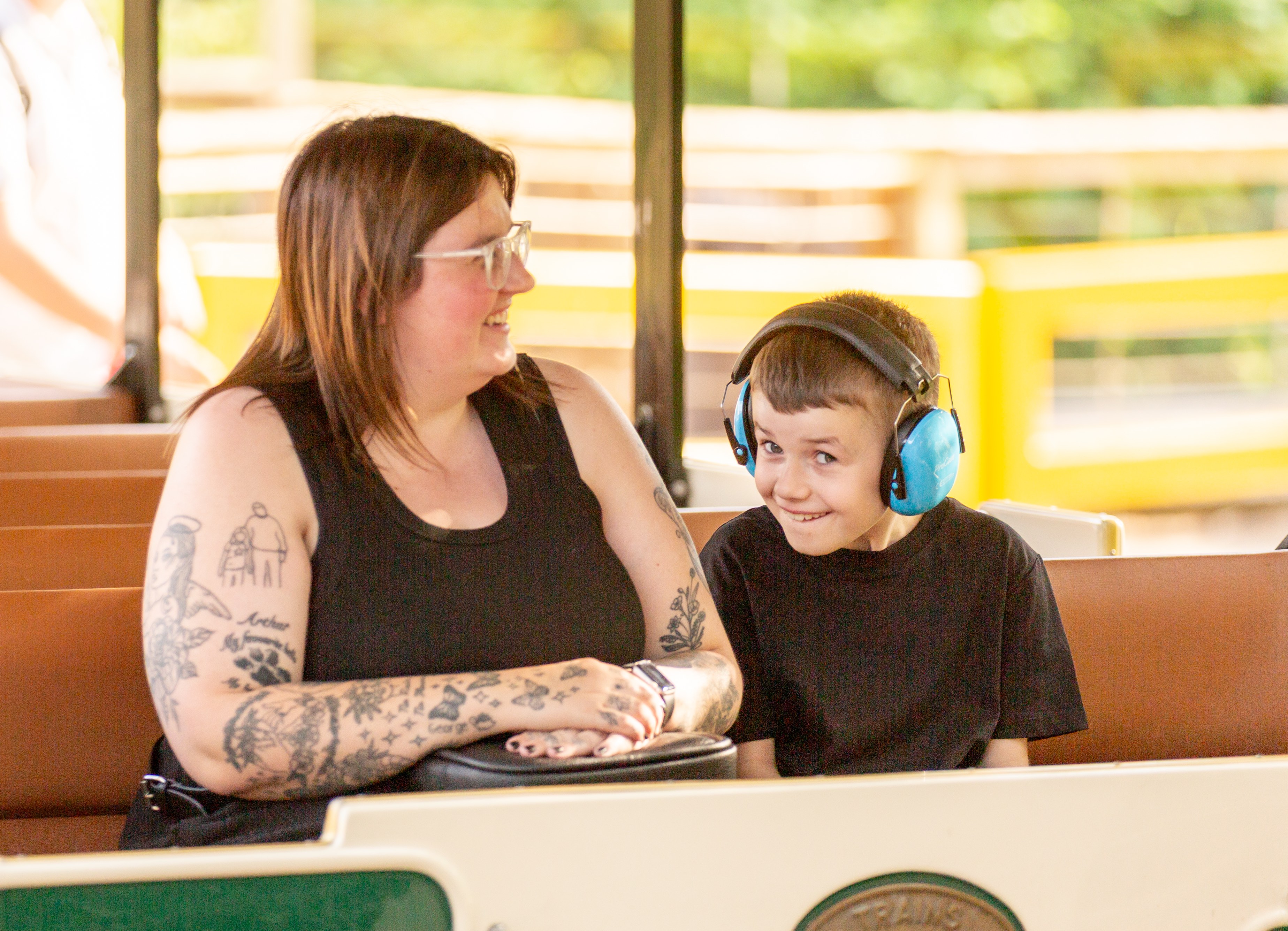 Mother bending down to comfort her child in a pushchair at a SEND Fest event