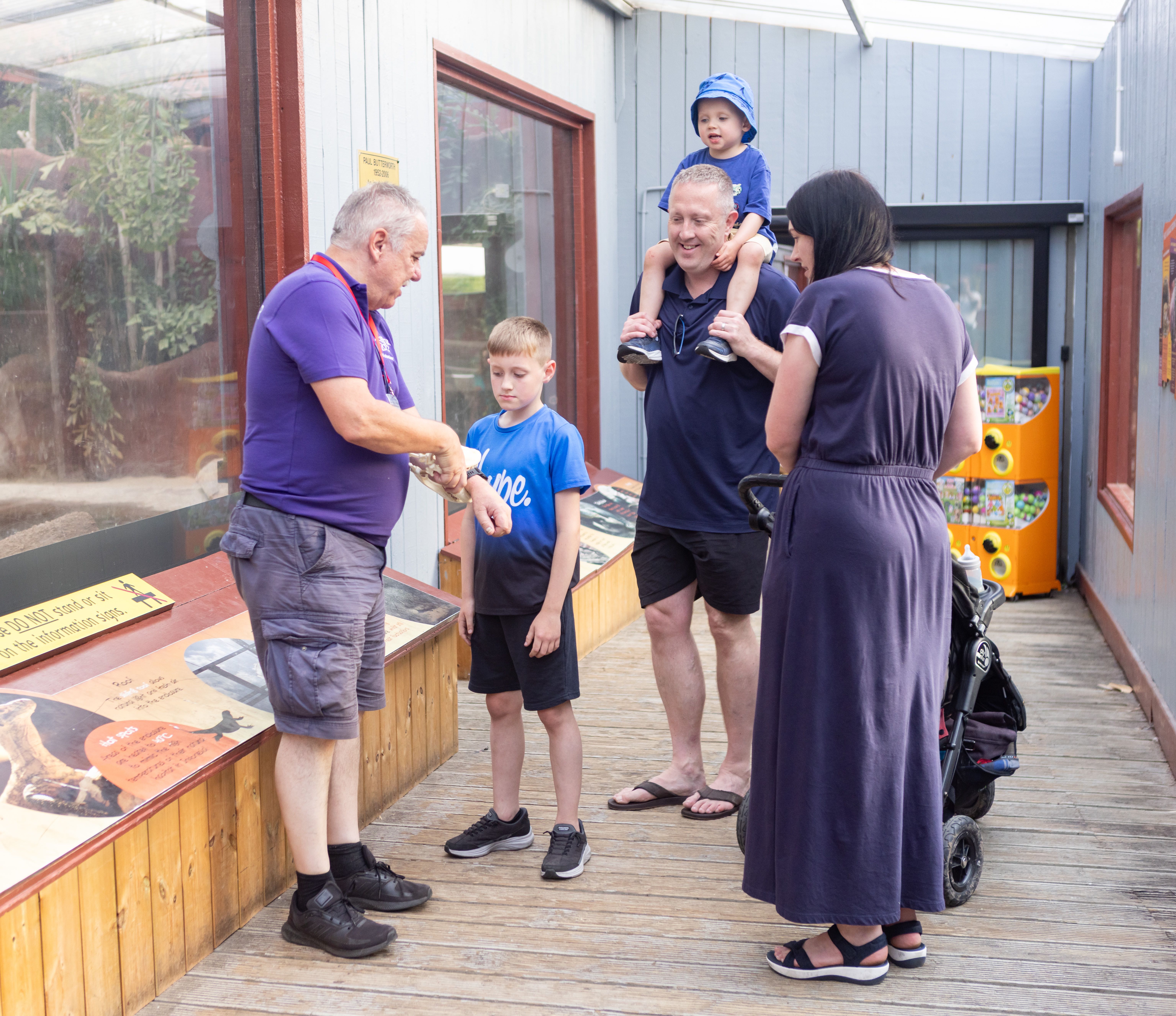 Child with Down Syndrome laughing as mum holds them at a picnic area