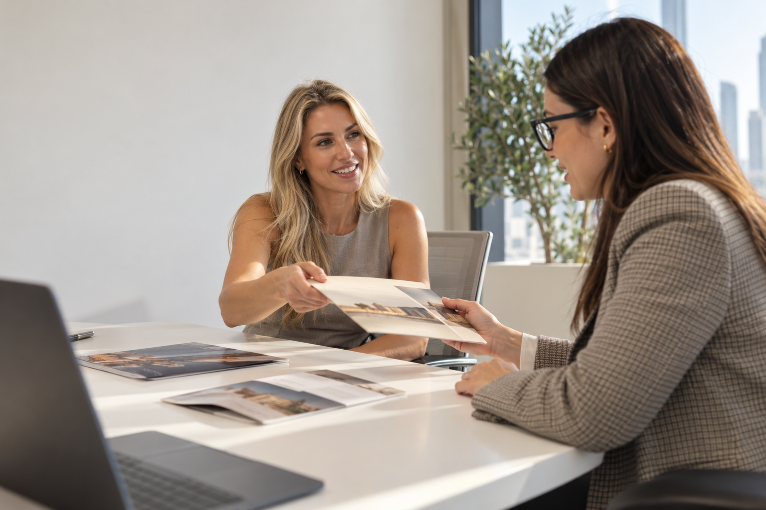 Consultant handing a brochure to a client in a Dubai office