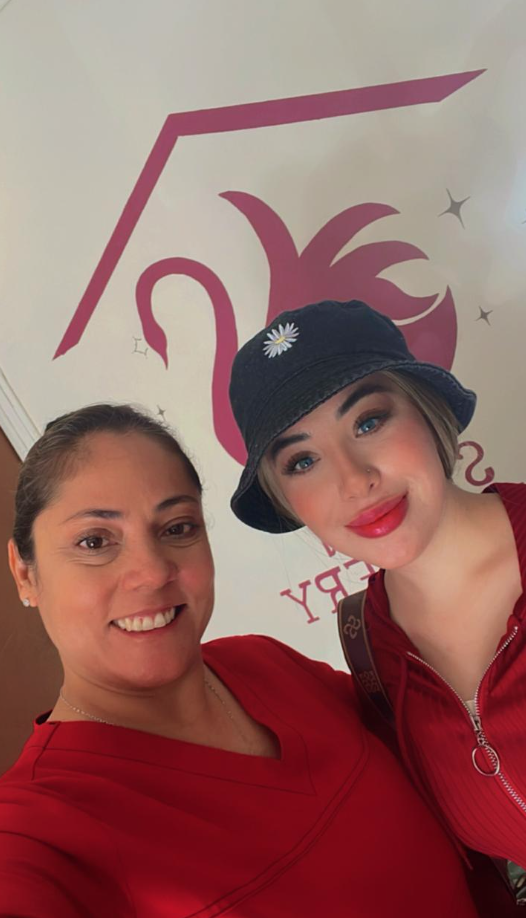 Paciente sonriendo junto a su cuidadora