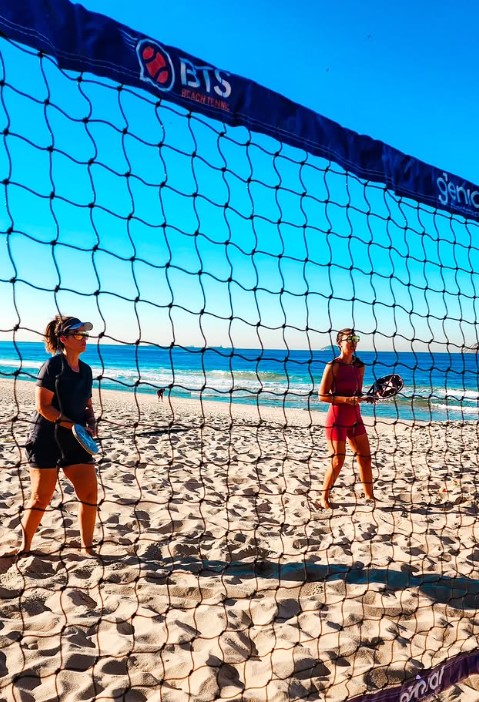 Duas jogadoras em uma quadra de Beach Tennis à beira-mar