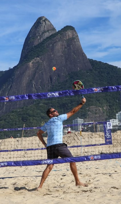 Jogador rebatendo em frente ao Morro Dois Irmãos