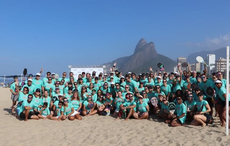 Grande grupo de participantes com camisetas azul-turquesa