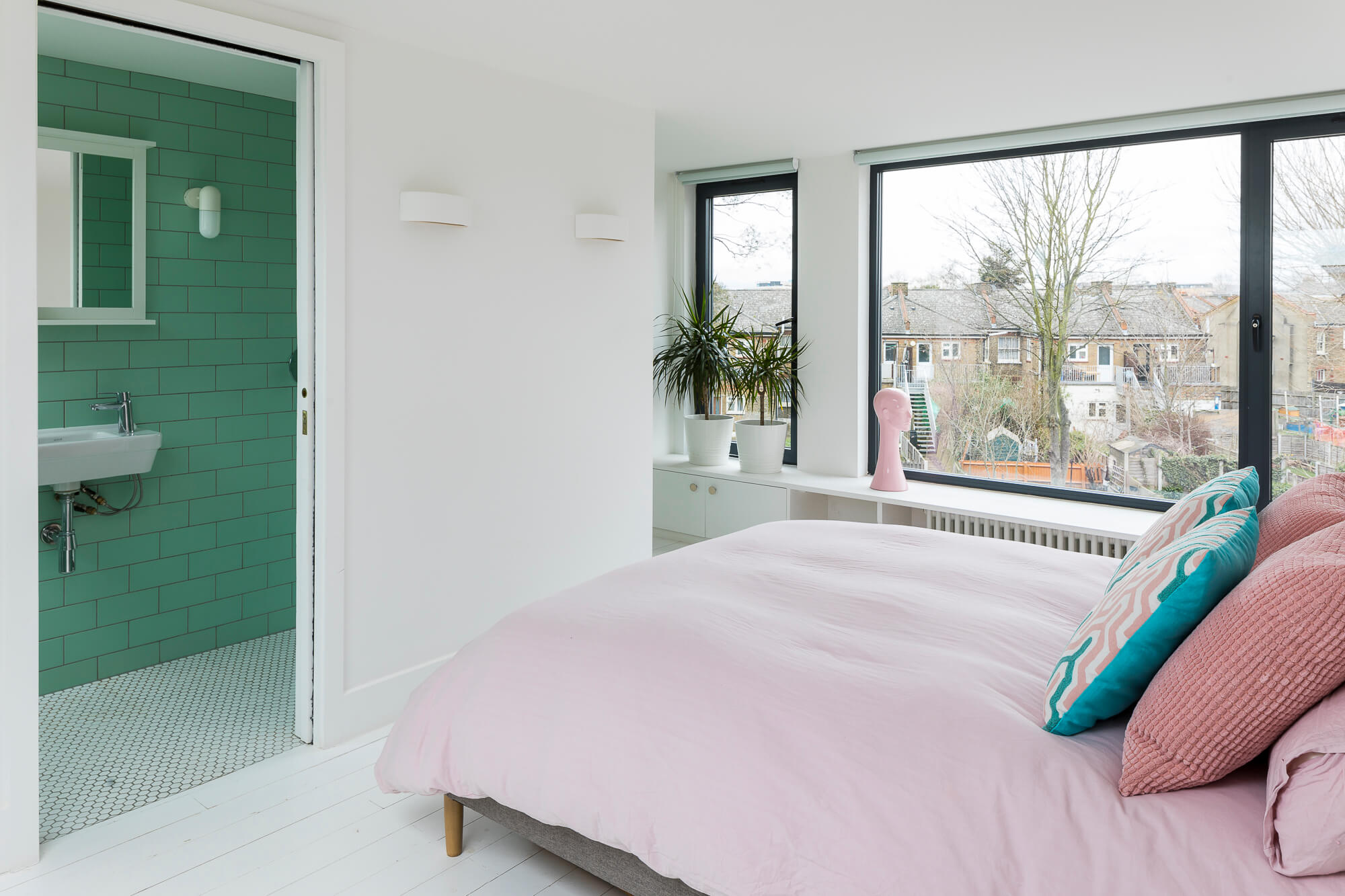 Master bedroom with en-suite bathroom featuring mint green tiles and pink bedding