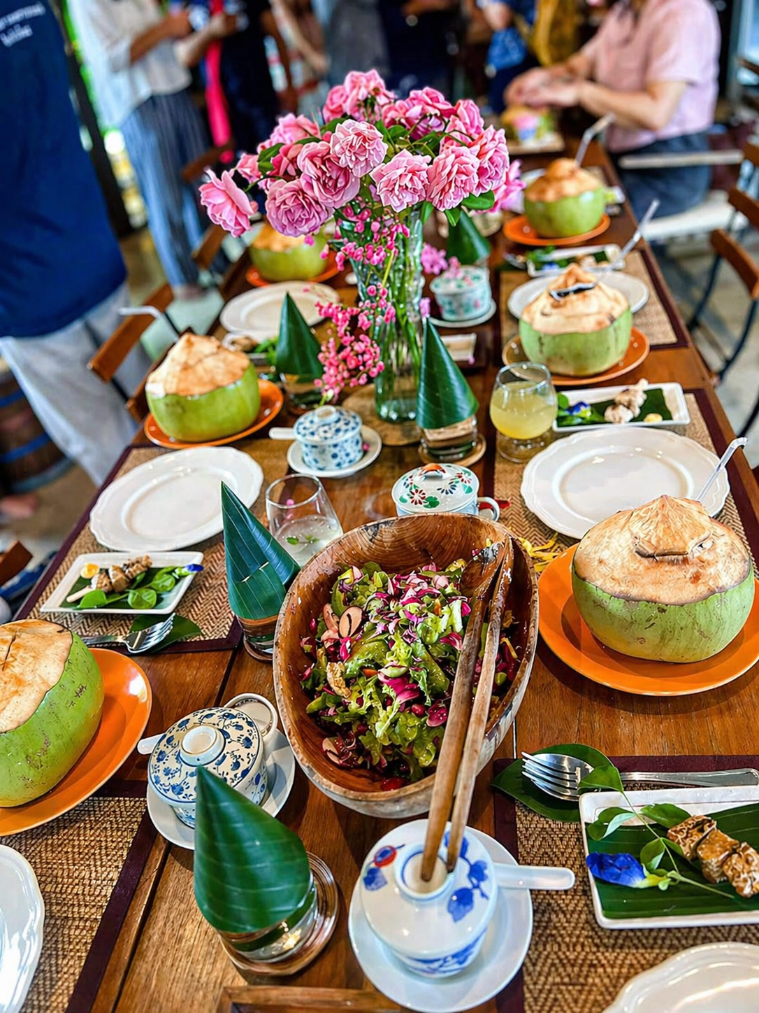 Beautifully set Thai dining table with coconuts and flowers