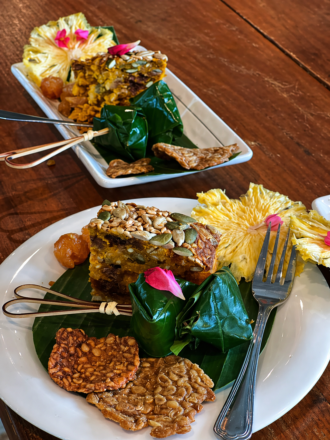 Thai desserts wrapped in banana leaf with pumpkin seed topping