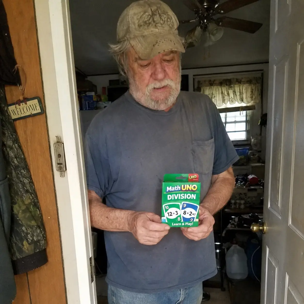 Man holding the Math Uno Division deck in a doorway