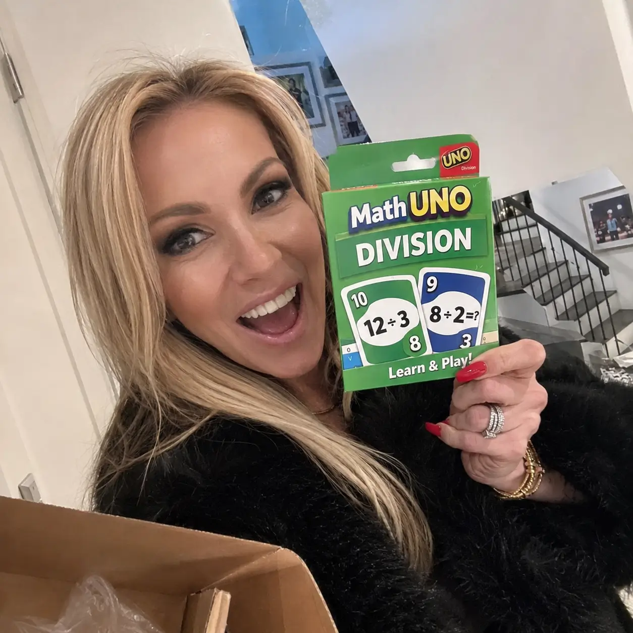 Woman smiling while holding the Math Uno Division deck