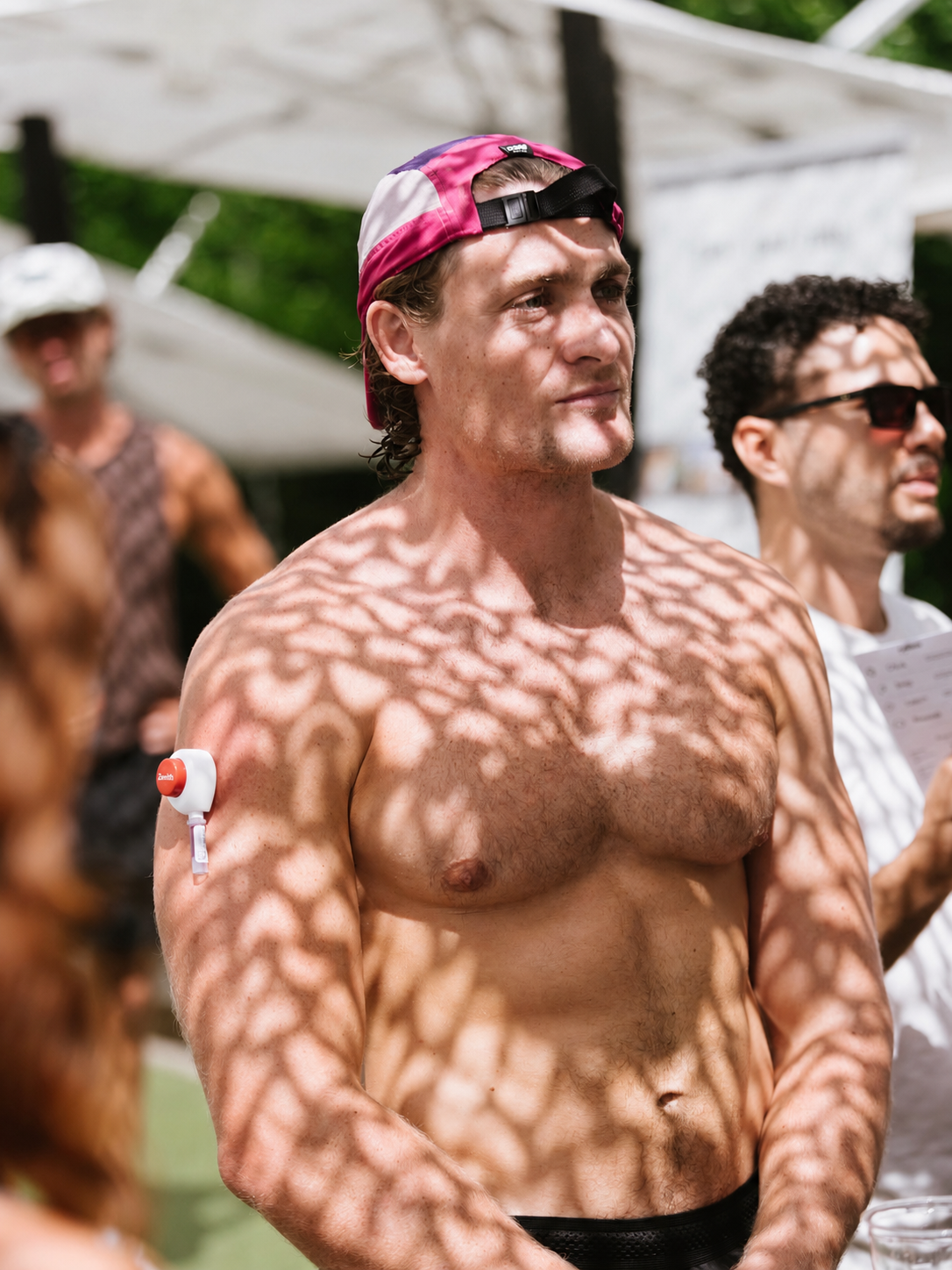 Man wearing the Zenith blood collection device outdoors at a social gathering