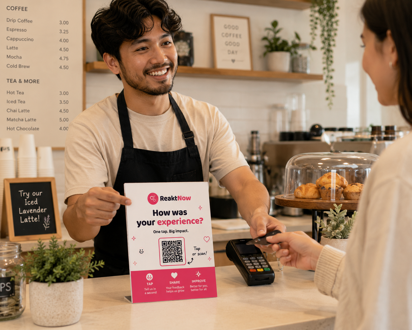 A barista points at a ReaktNow counter placard while a customer pays at the till