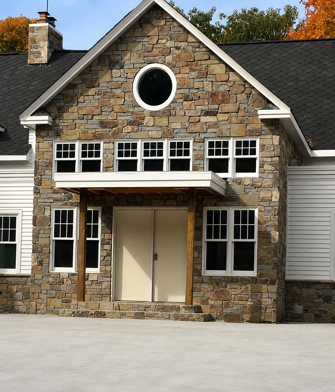 Studer Masonry stone home featuring expertly coursed tan and golden stone masonry facade.
