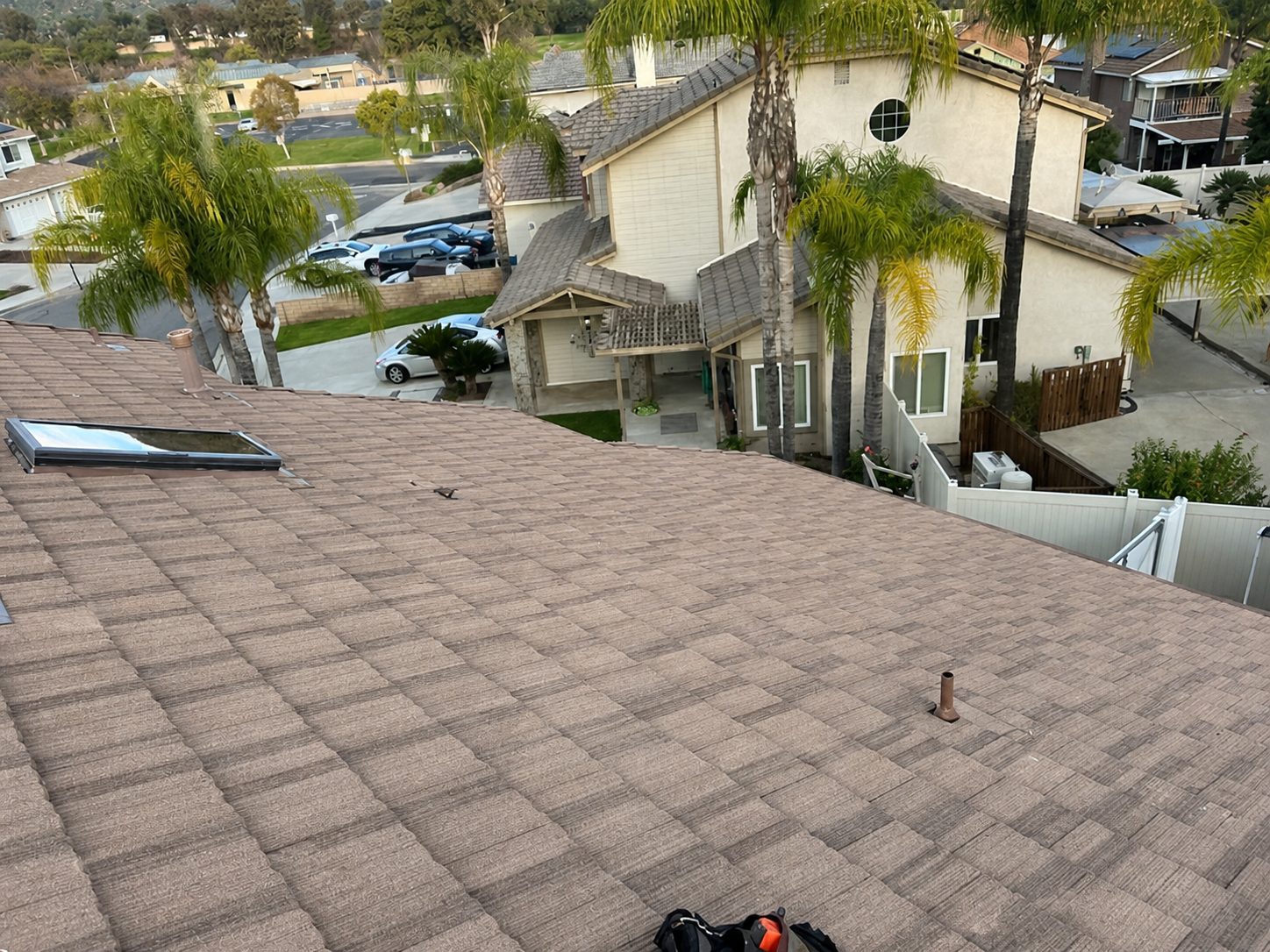 Completed shingle and flat roof installation with skylight on Southern California home