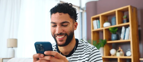 Young man smiling while using his phone