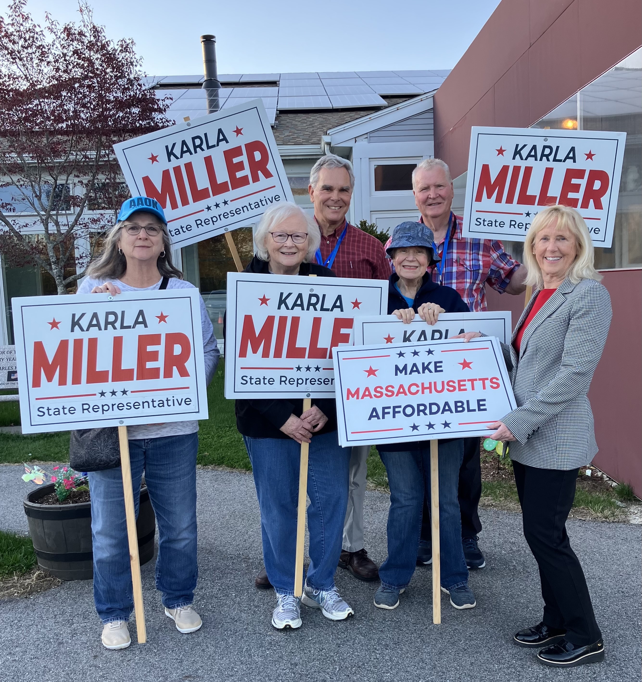 Karla Miller with supporters holding campaign signs at Chelmsford Town Meeting