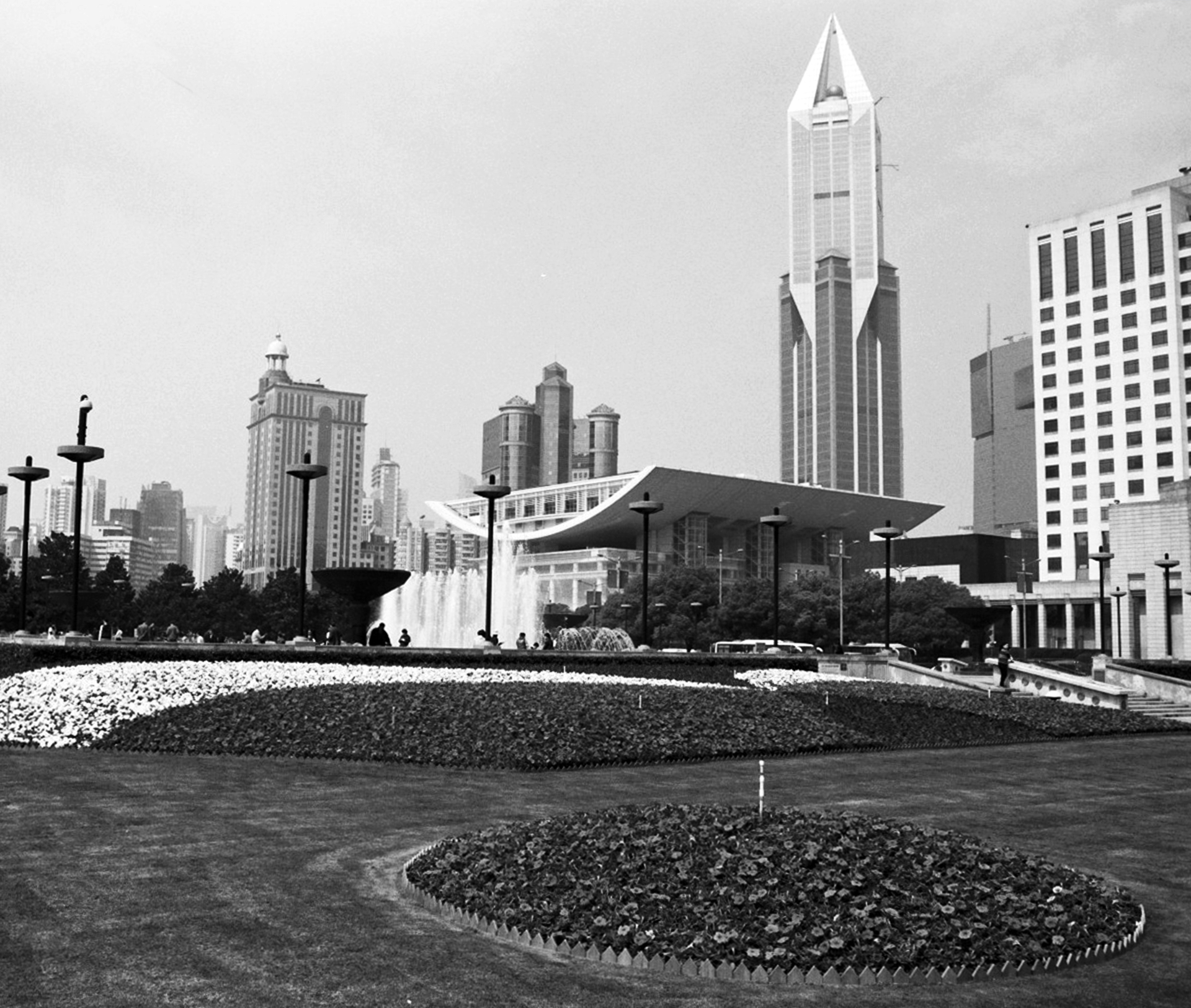 Urban plaza and square with tall pointed modern building church and fountain