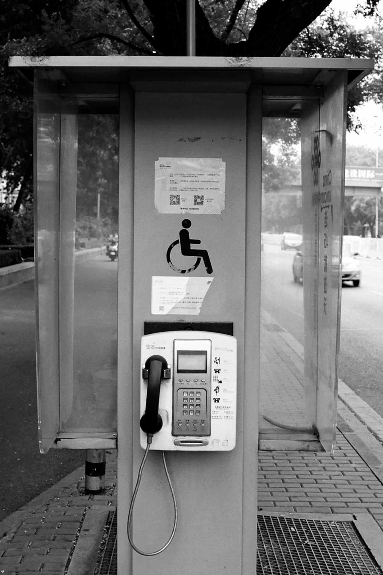 Public phone booth interior with handicap accessibility symbol on door