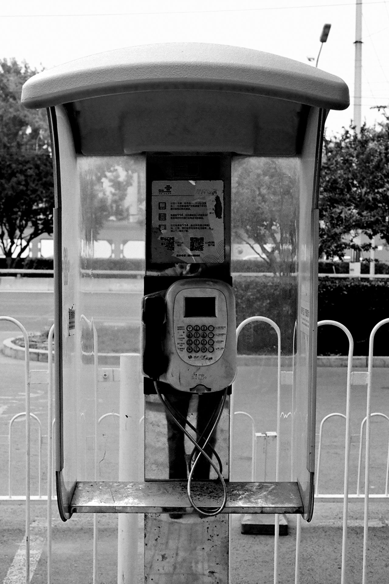 Public phone booth with accessibility symbol and information posters