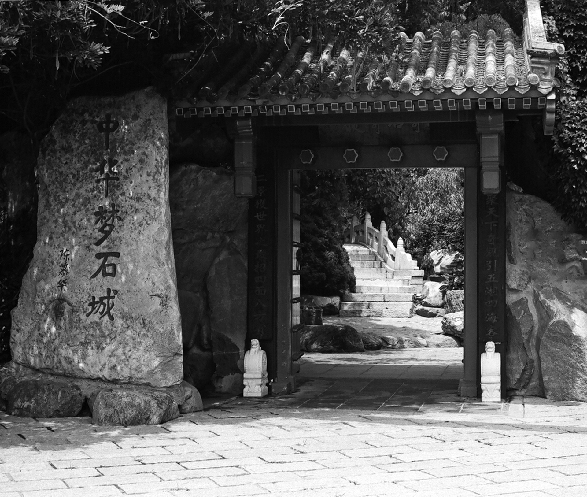 Stone gate and archway entrance to temple with carved stone guardian elements