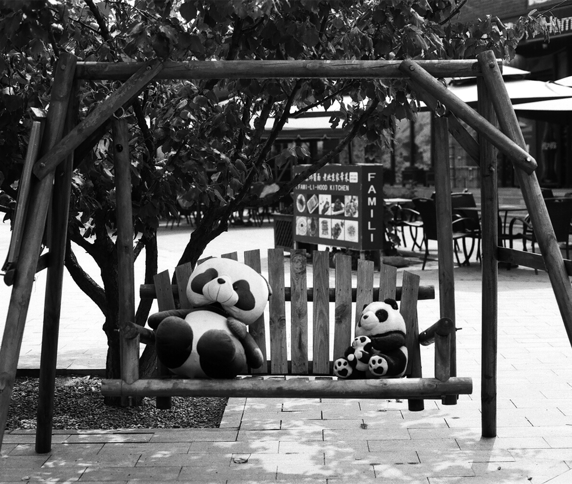 Panda plush toys visible in playground area under pergola structure