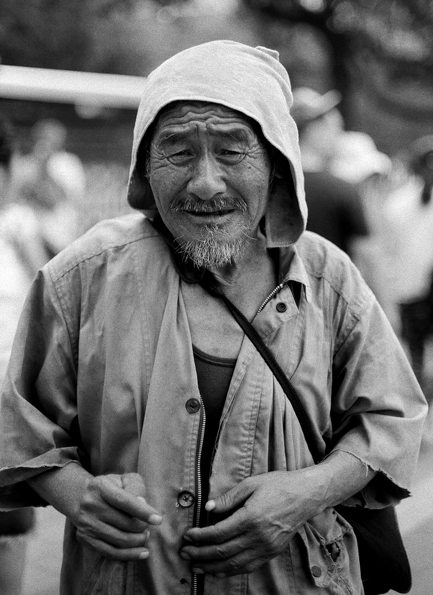 Portrait of elderly man wearing light colored jacket and white head covering