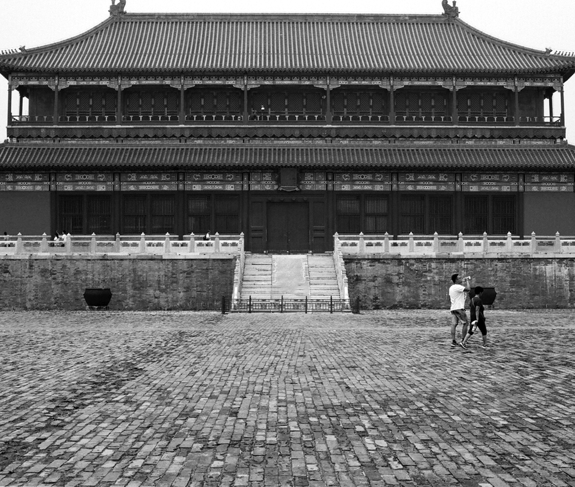 Wide ceremonial courtyard plaza in front of traditional Chinese imperial building with curved roof