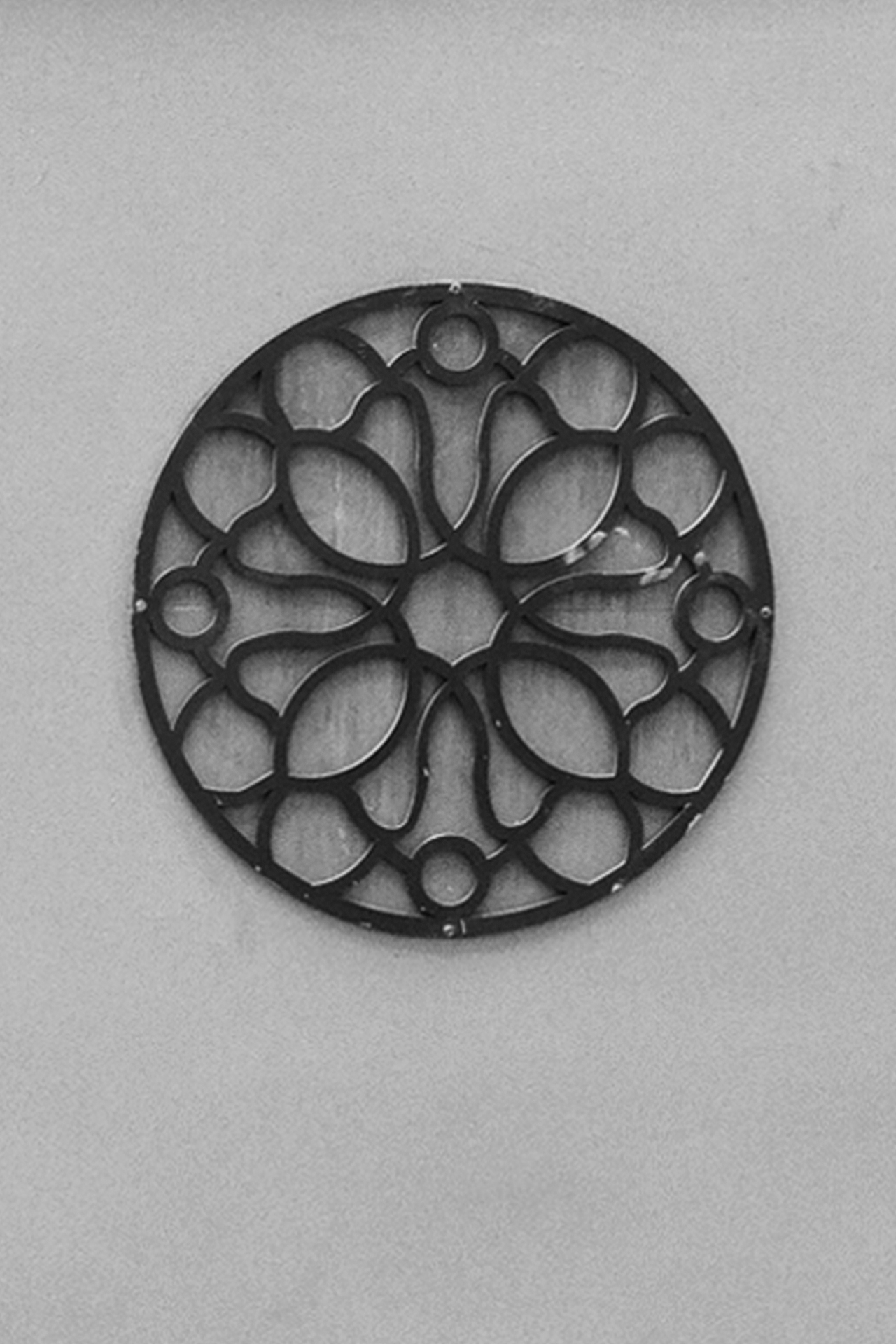 Circular decorative metal relief sculpture with organic petal and leaf-like shapes