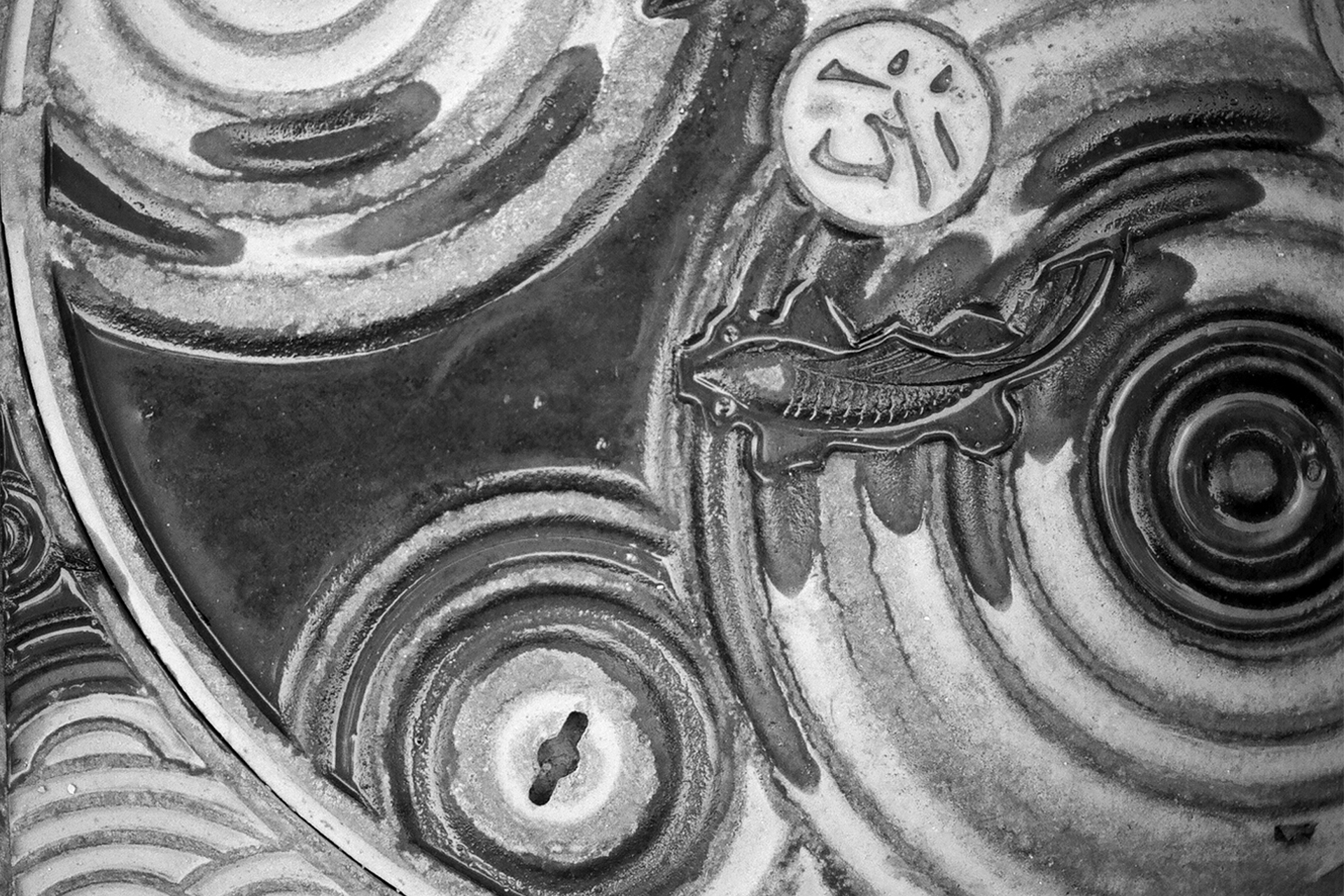 Close-up of ornamental stone architectural relief with carved circular patterns and organic swirling designs