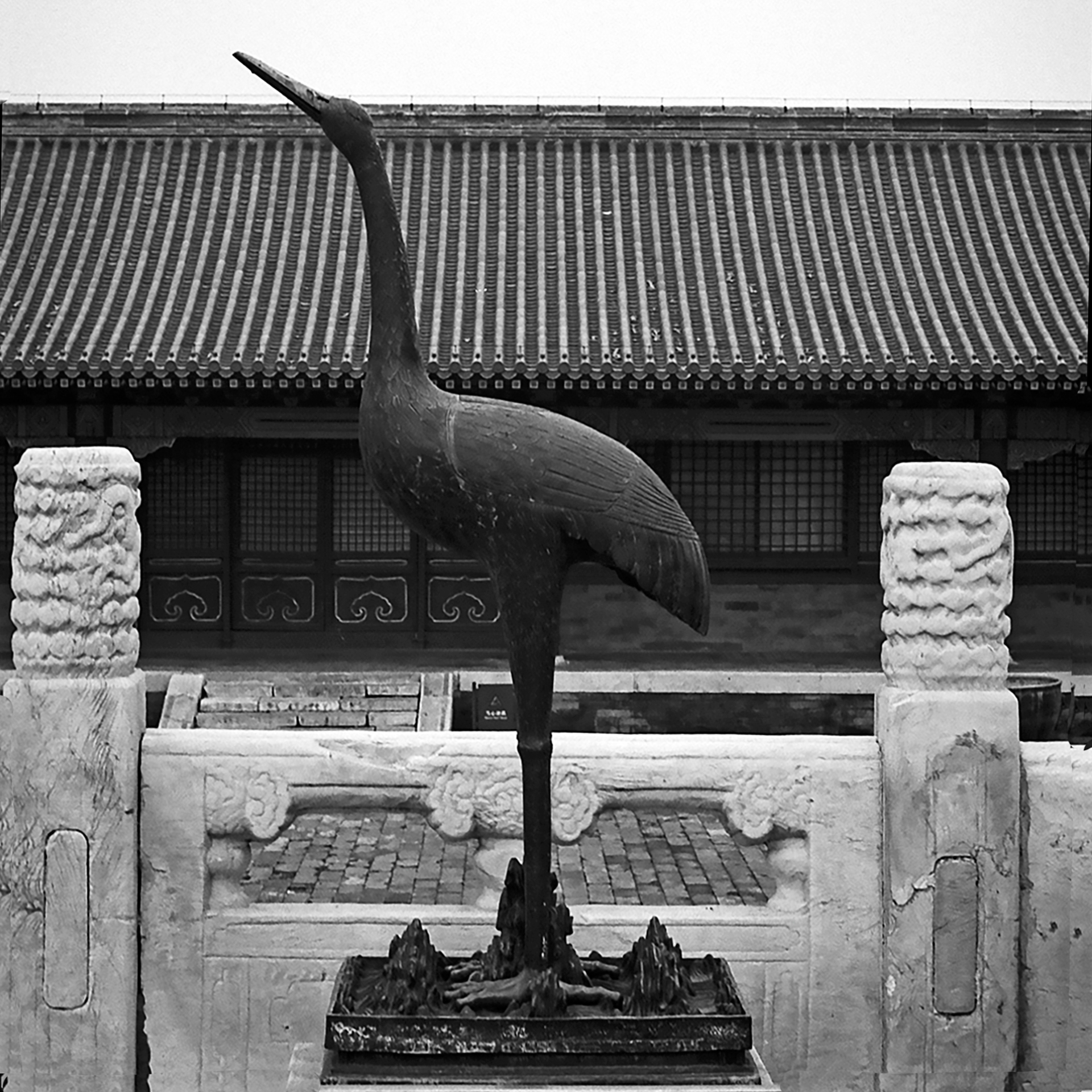 Large ceremonial crane sculpture against temple roof with ornamental columns and traditional architecture