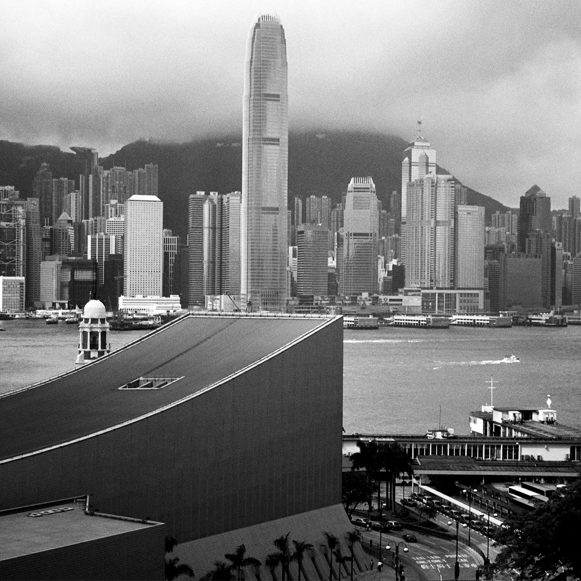 Hong Kong harbor panorama with curved pier architectural structure and skyline with mountains
