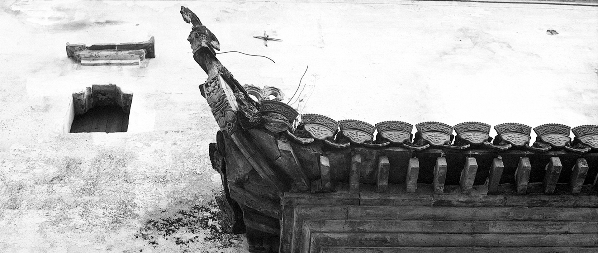 Ornate wooden carved boat prow with dragon head and decorative ceramic finials in white sand