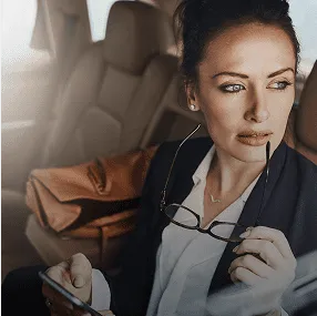 Professional woman working on phone in car