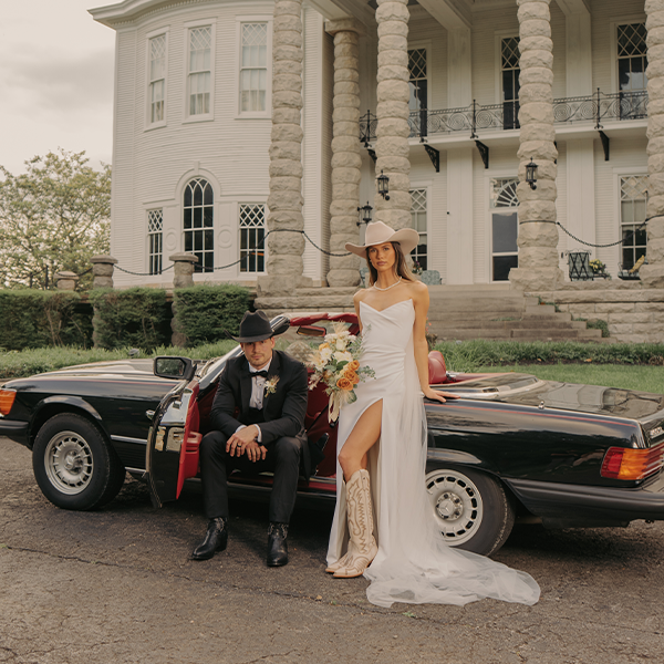 Bridal couple with vintage convertible at estate