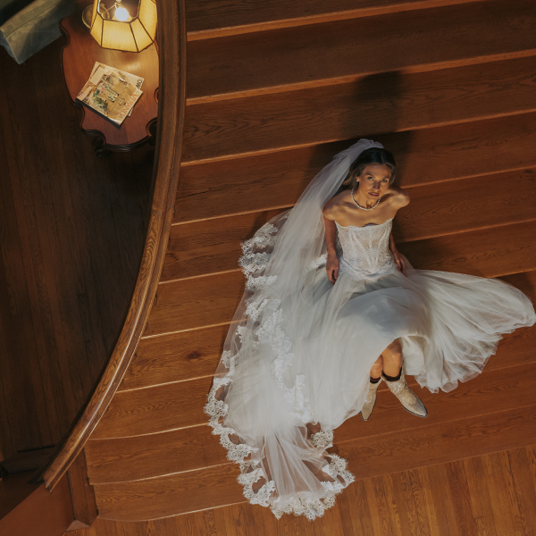 Bride on staircase with lace veil and cowboy boots