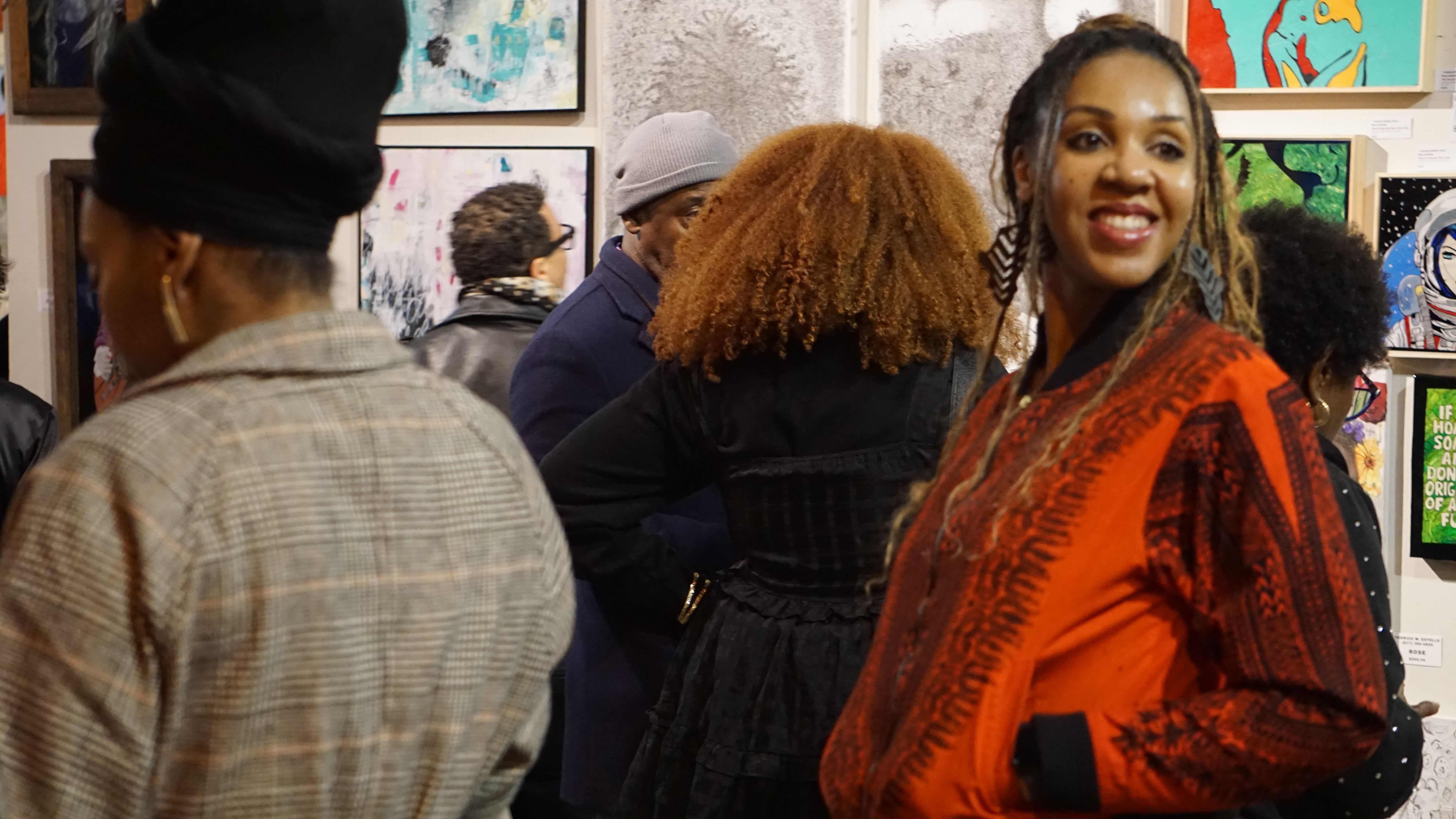Attendees browsing art gallery with colorful paintings