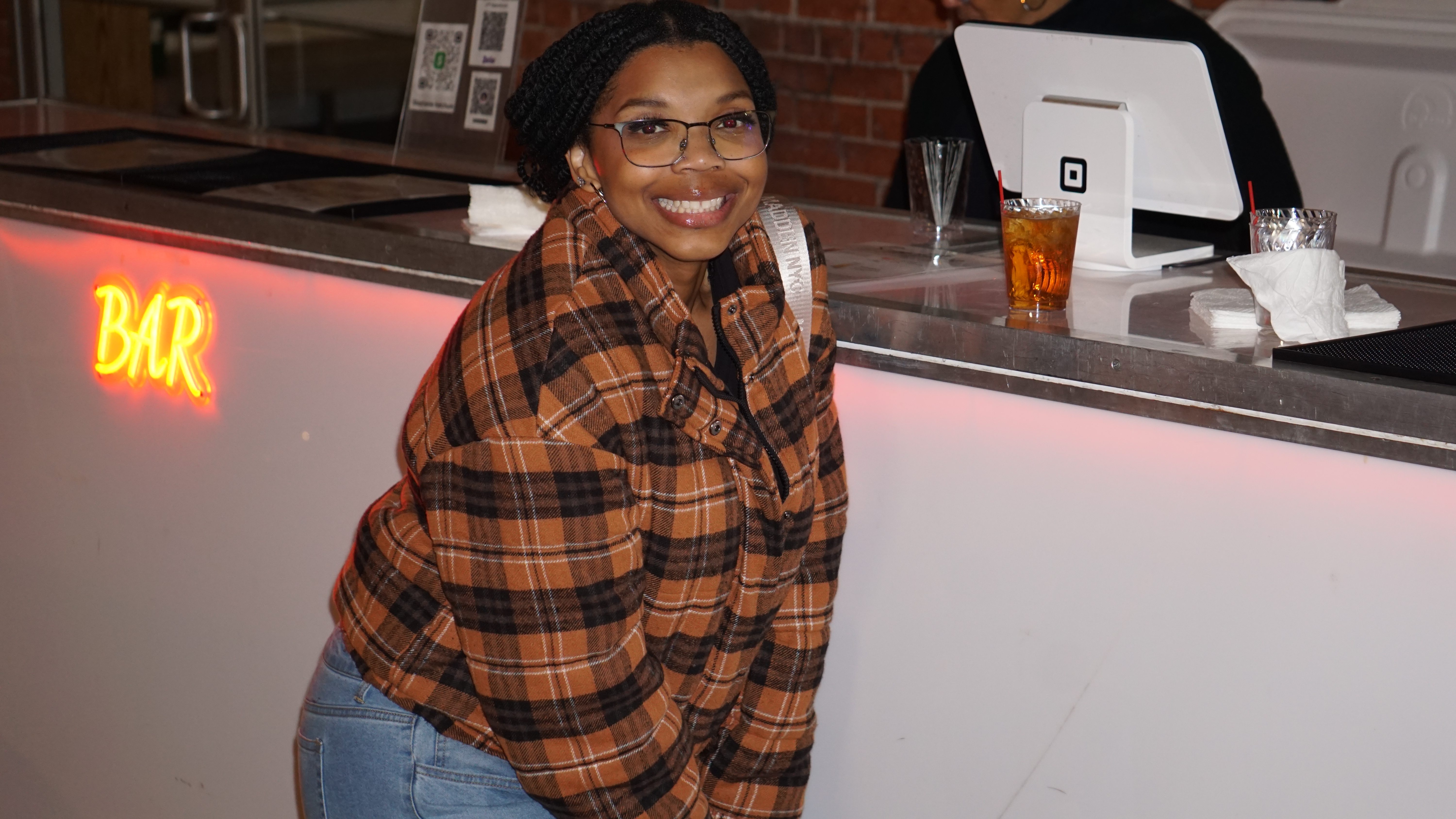 Happy attendee at bar with neon sign
