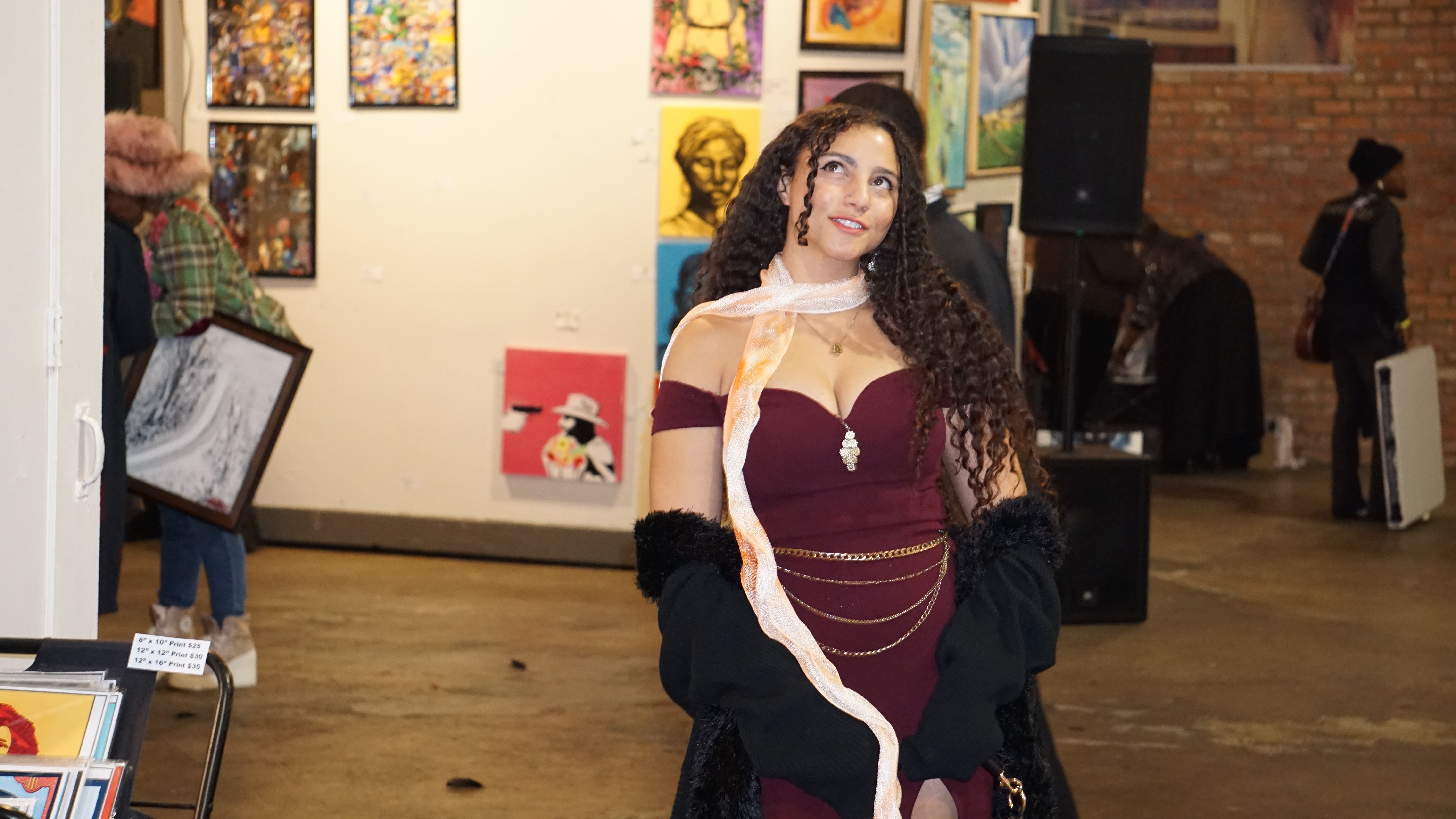 Elegant attendee in burgundy dress viewing artwork