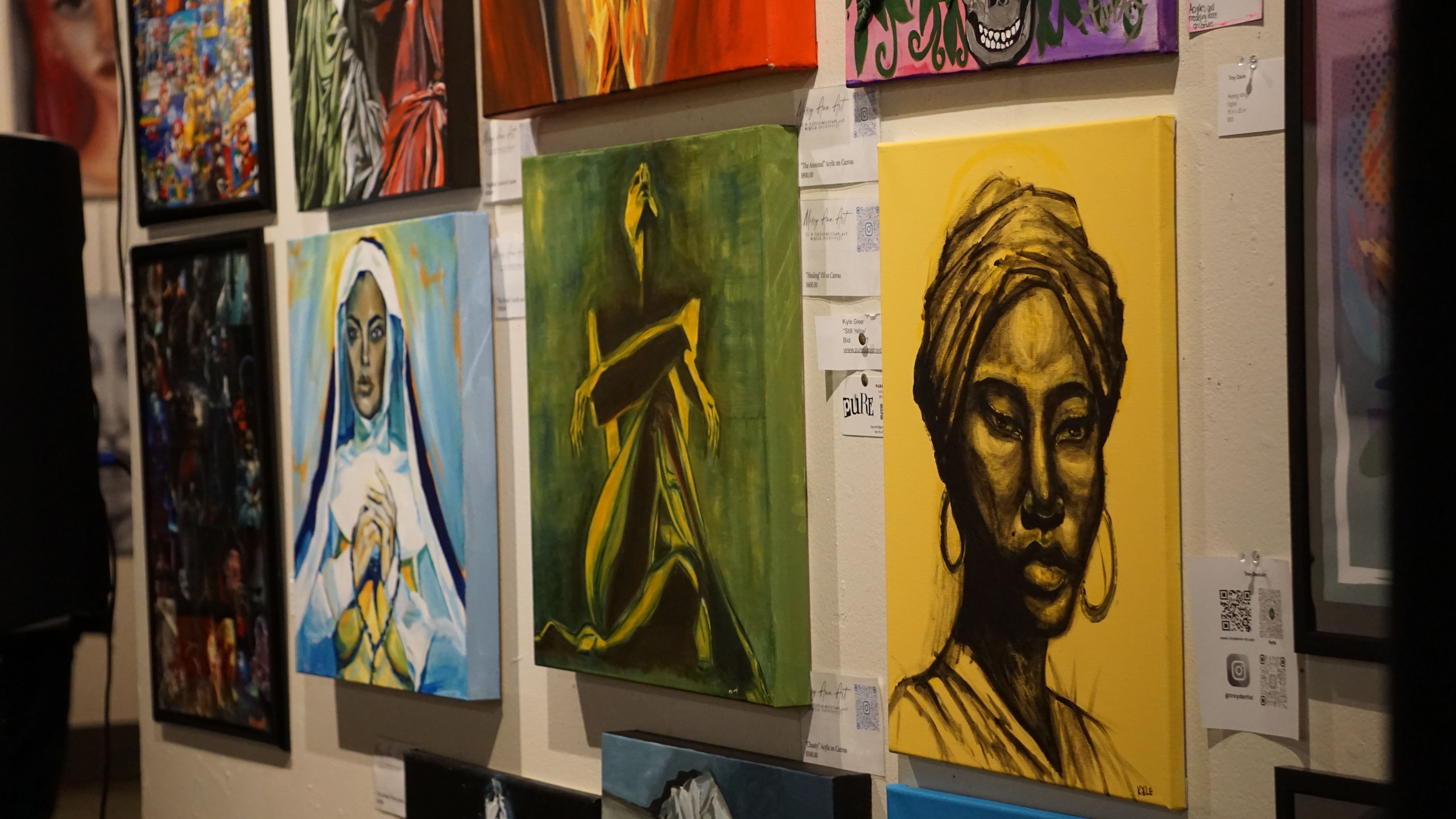 Gallery wall with yellow and green portrait paintings