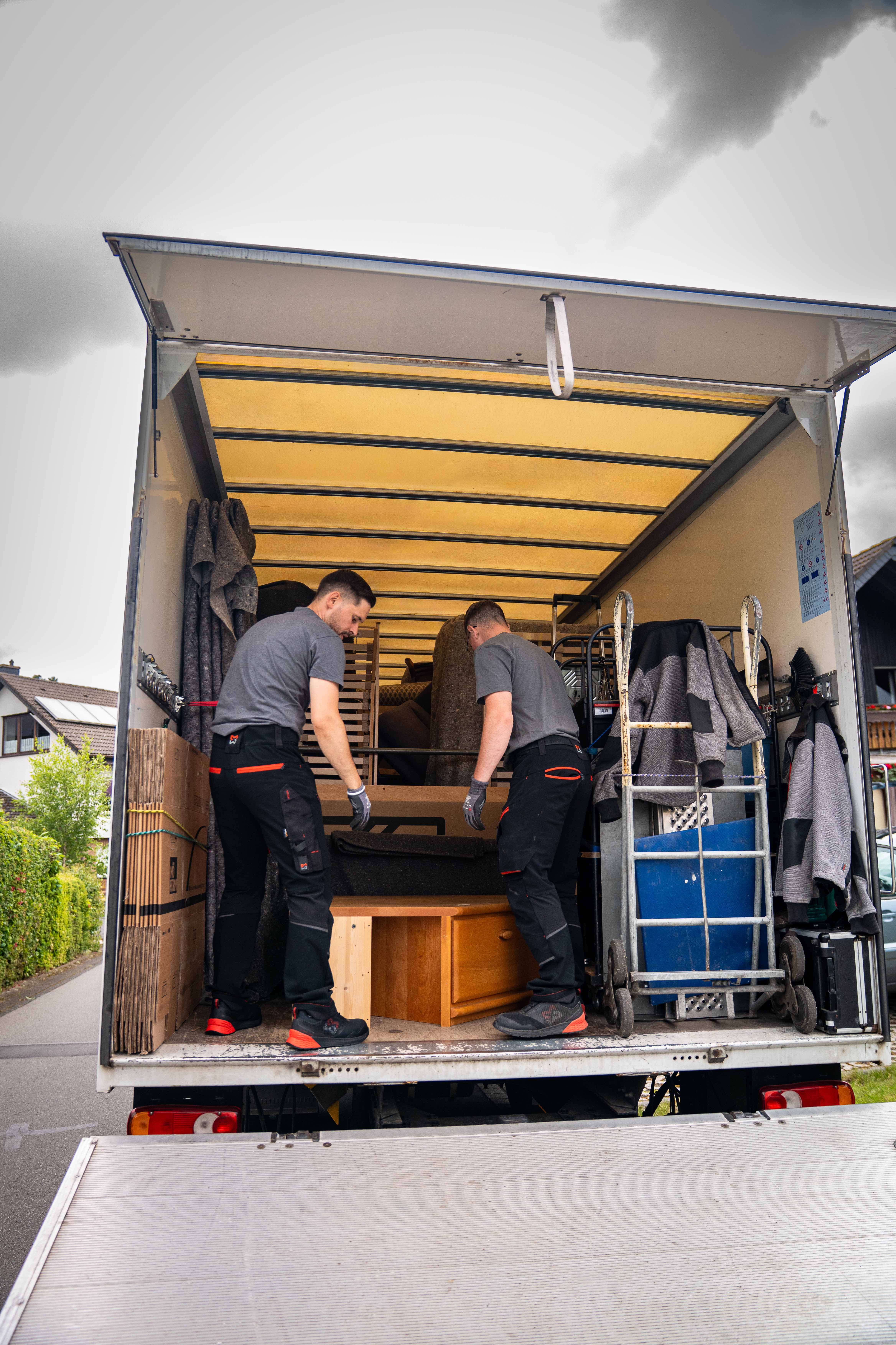 Zwei Koch Umzüge Mitarbeiter organisieren Möbel und Umzugsgut im LKW