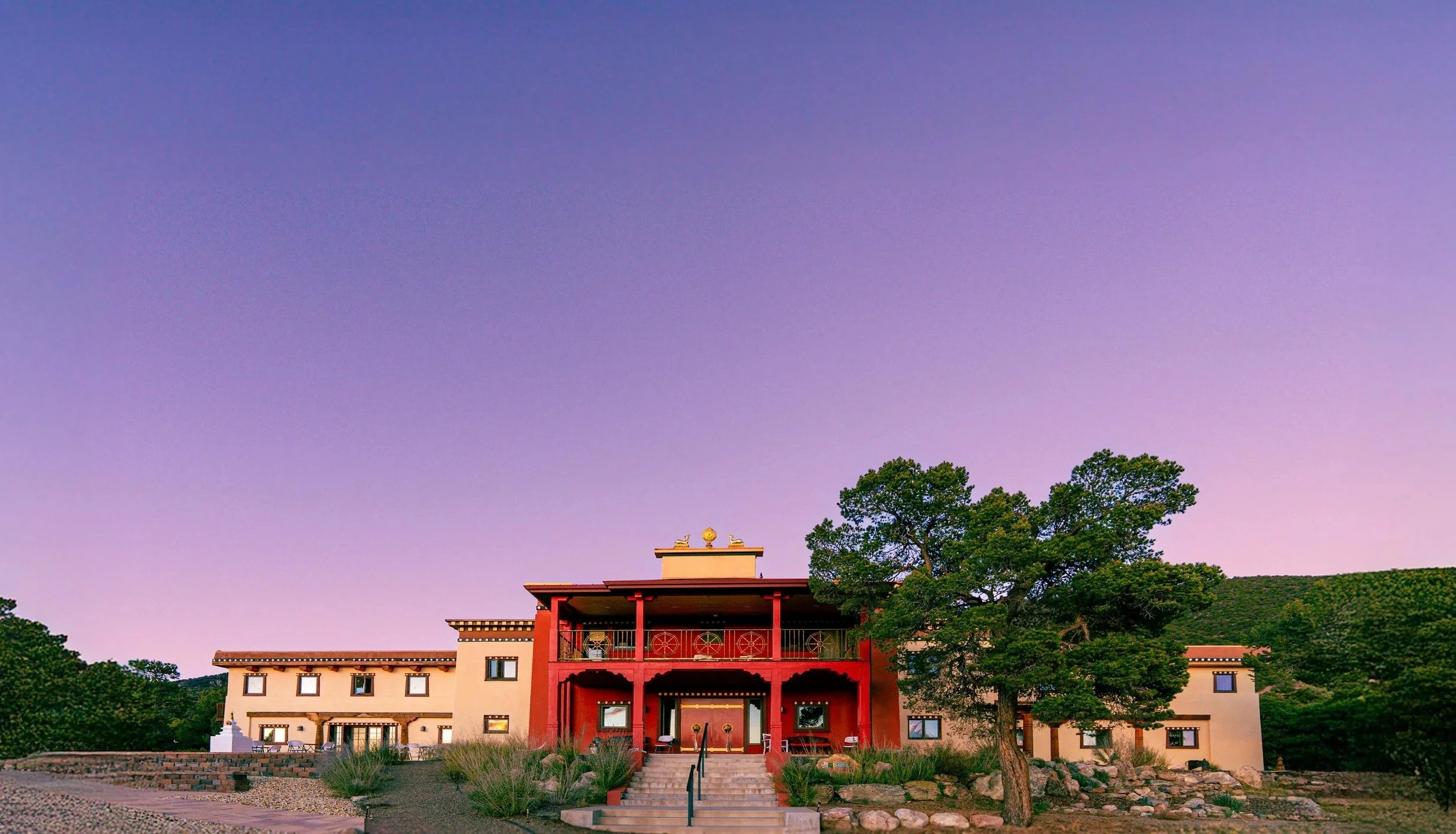 Vajra Vidya Retreat Center in Crestone at dusk — a stunning Tibetan-style building with purple sky