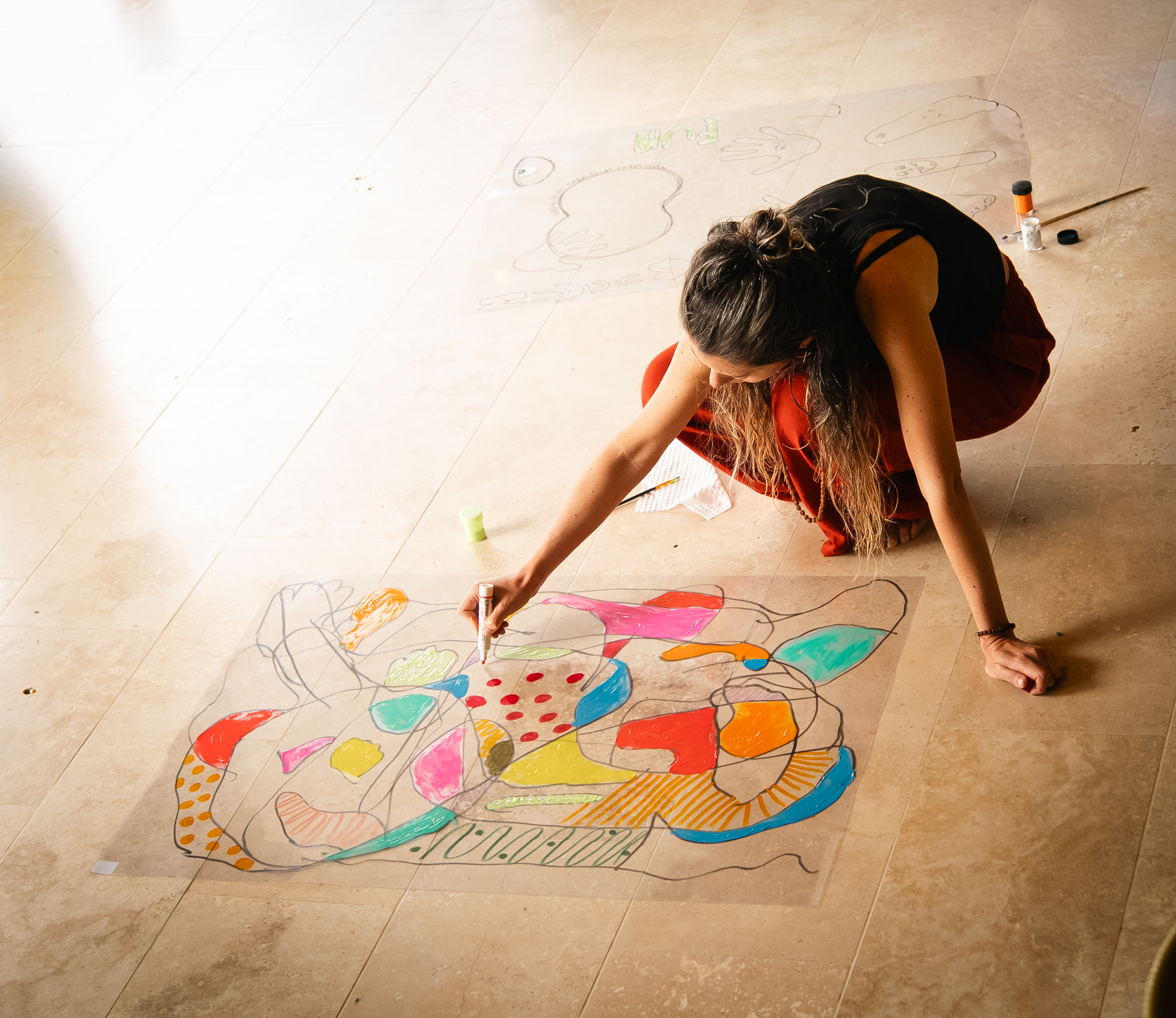 Mujer creando arte abstracto colorido en el suelo