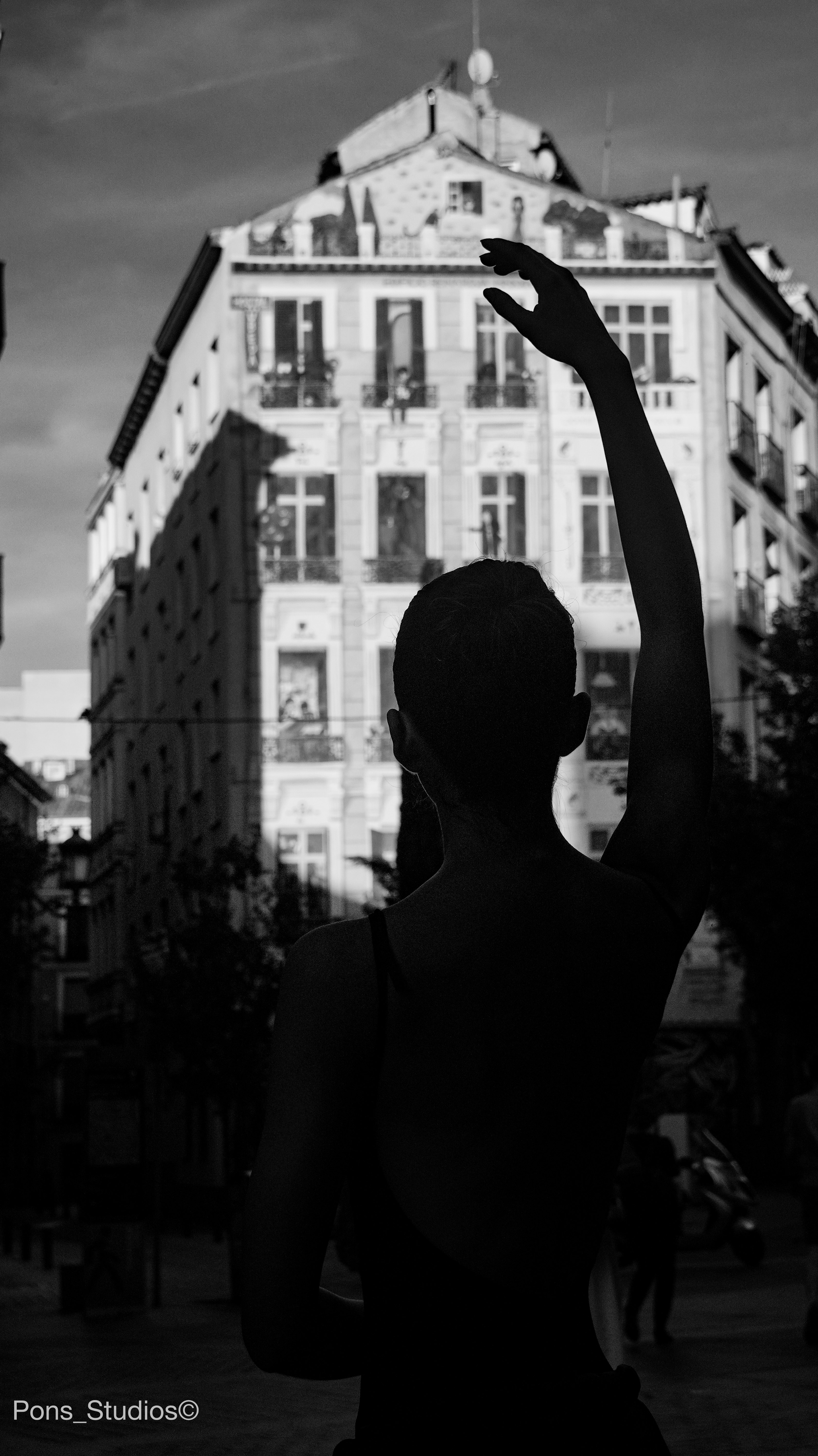 Ballet dancer silhouetted against a city building